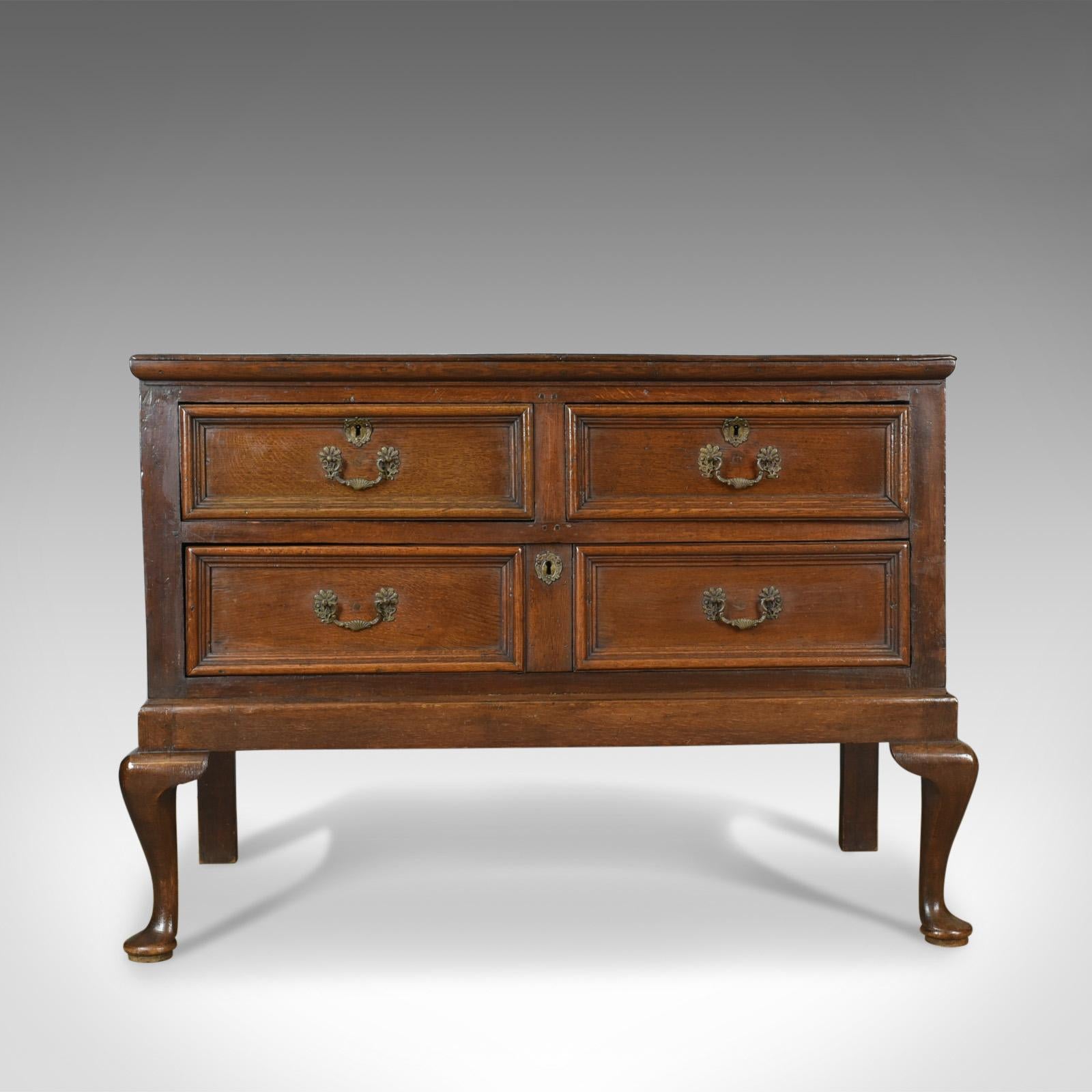 This is an antique chest on stand, an English, Early Georgian, oak chest of drawers dating to the early 18th century, circa 1720.

Broad and deep chest of pleasing proportions
Solid English oak with good color throughout
Grain interest