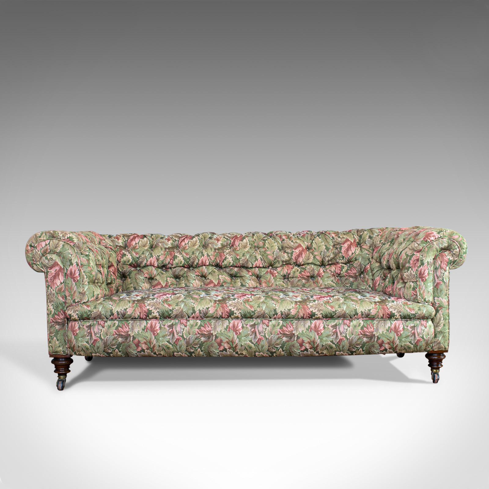 This is an antique Chesterfield sofa. An English, textile and mahogany upholstered couch with seating for 2-3 people and dating to the late 19th century, circa 1880.

Professionally upholstered with consistent colour and good order