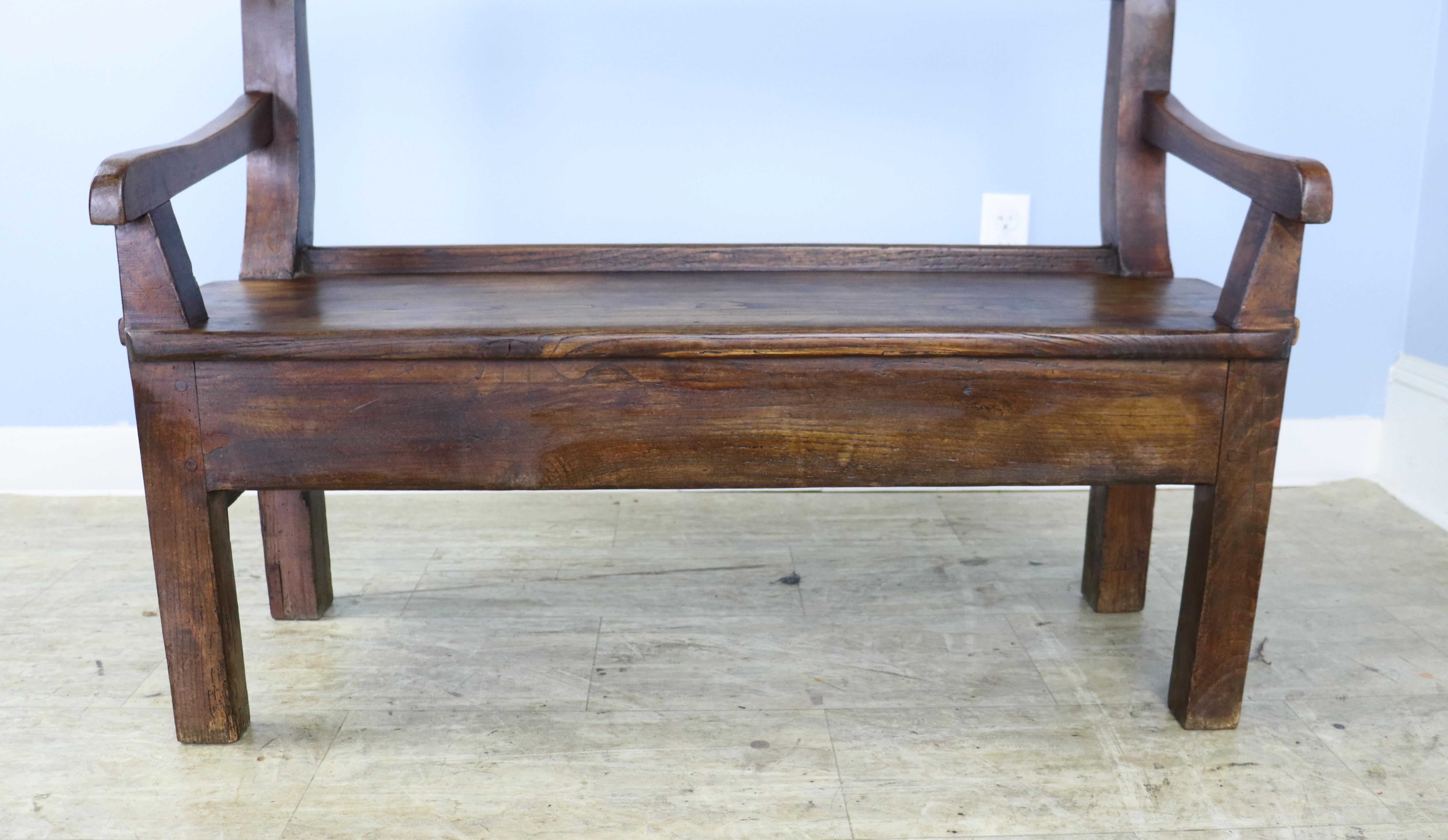 A country chestnut bench with good chestnut grain, color and patina.   A simple silhouette with a gently sloping back and sweet arms,  the back with some interesting old distress.   The small drawer at one end of the seat adds a nice design note. 