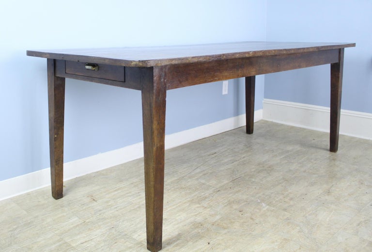 A handsome, generously proportioned farm table with tapered legs and rounded edges at the top in dark, richly colored chestnut. Great 35.25