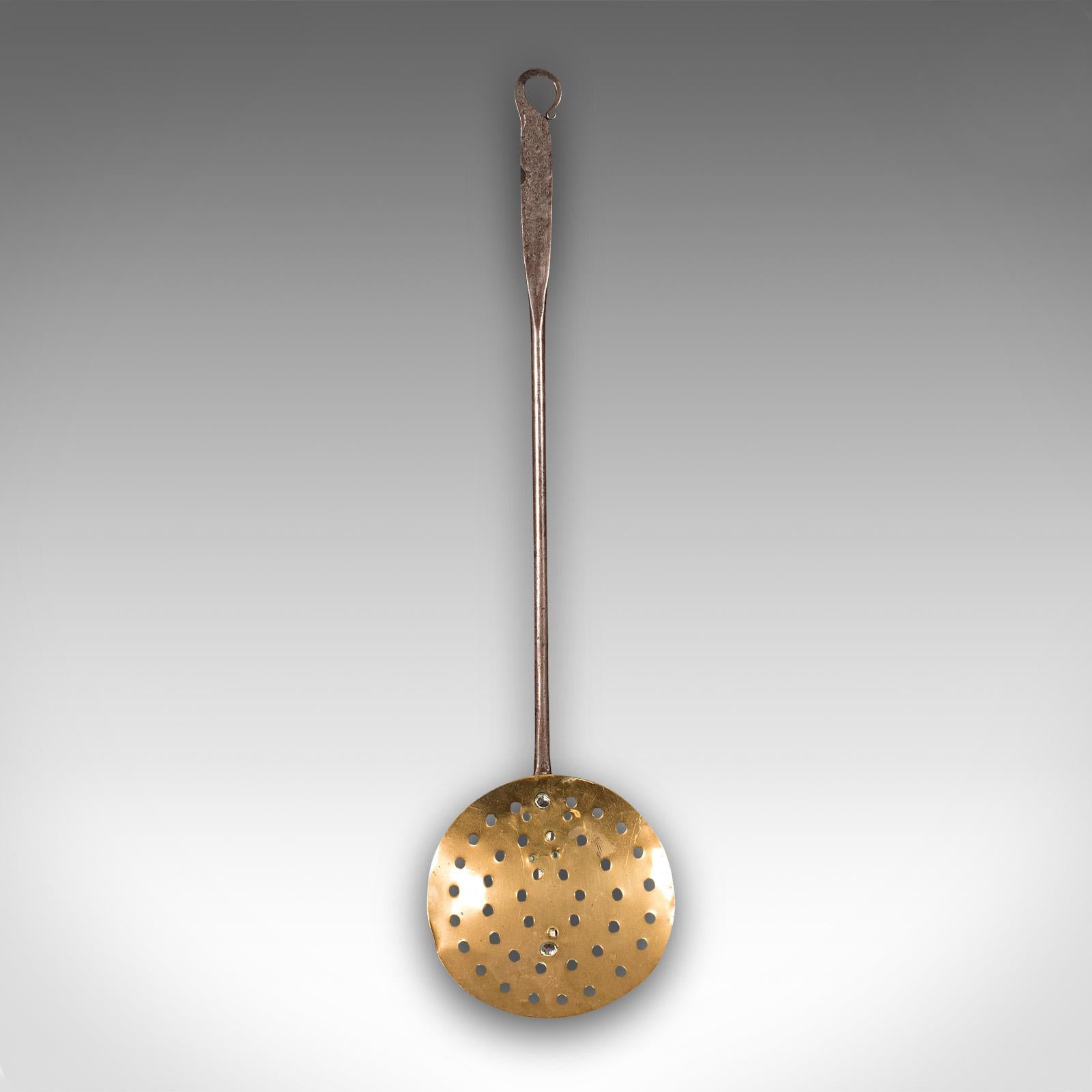 This is an antique chestnut warmer. An English, brass and cast iron fireplace roaster or ladle, dating to the Georgian period, circa 1800.

Fascinating fireside tool or decorative roaster from the Georgian period
Displays a desirable aged patina