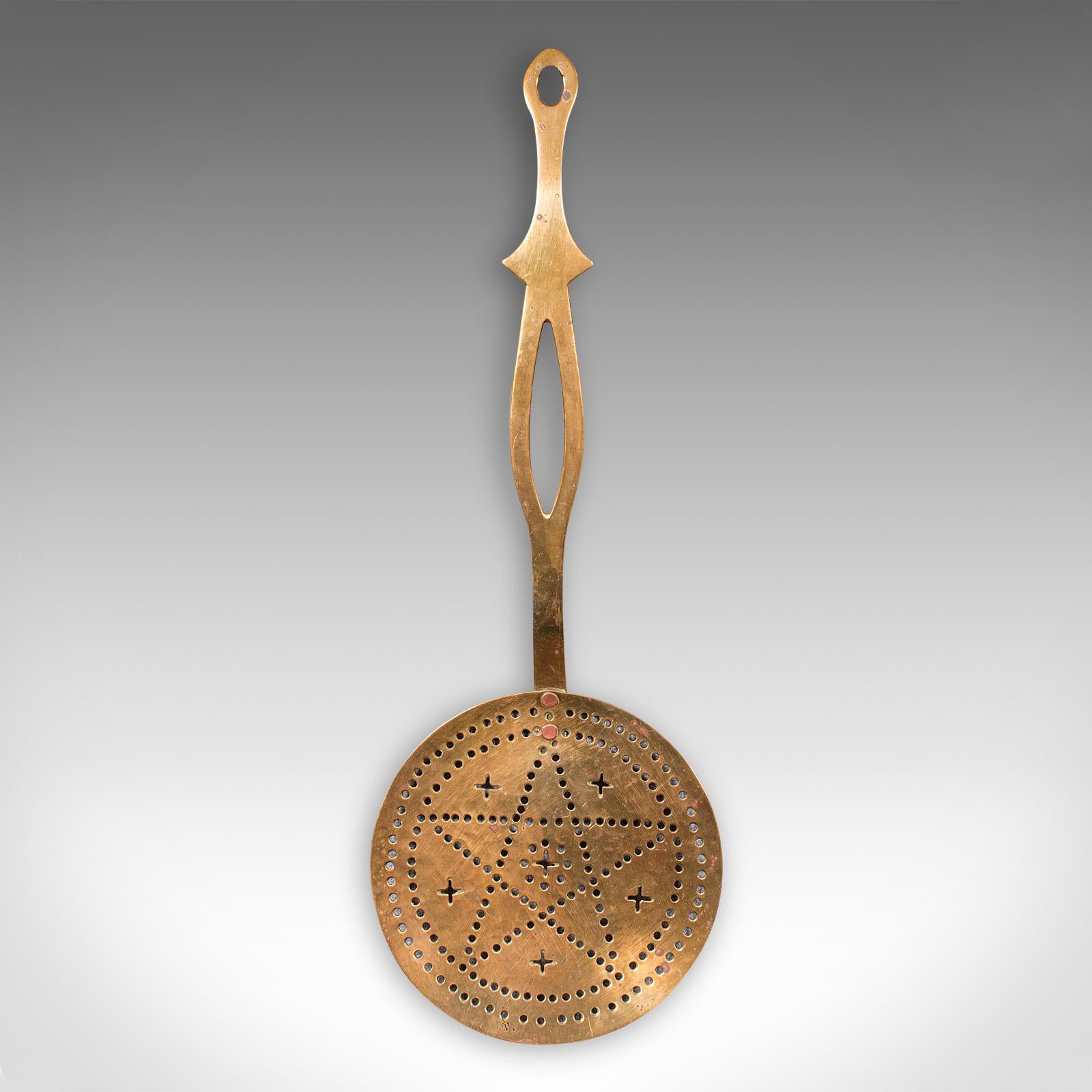 
This is an antique chestnut warmer. An English, brass fireside crumpet toaster, dating to the Georgian period, circa 1800.

Strikingly decorated warmer with great colour
Displays a desirable aged patina throughout
Brass presents golden tonality