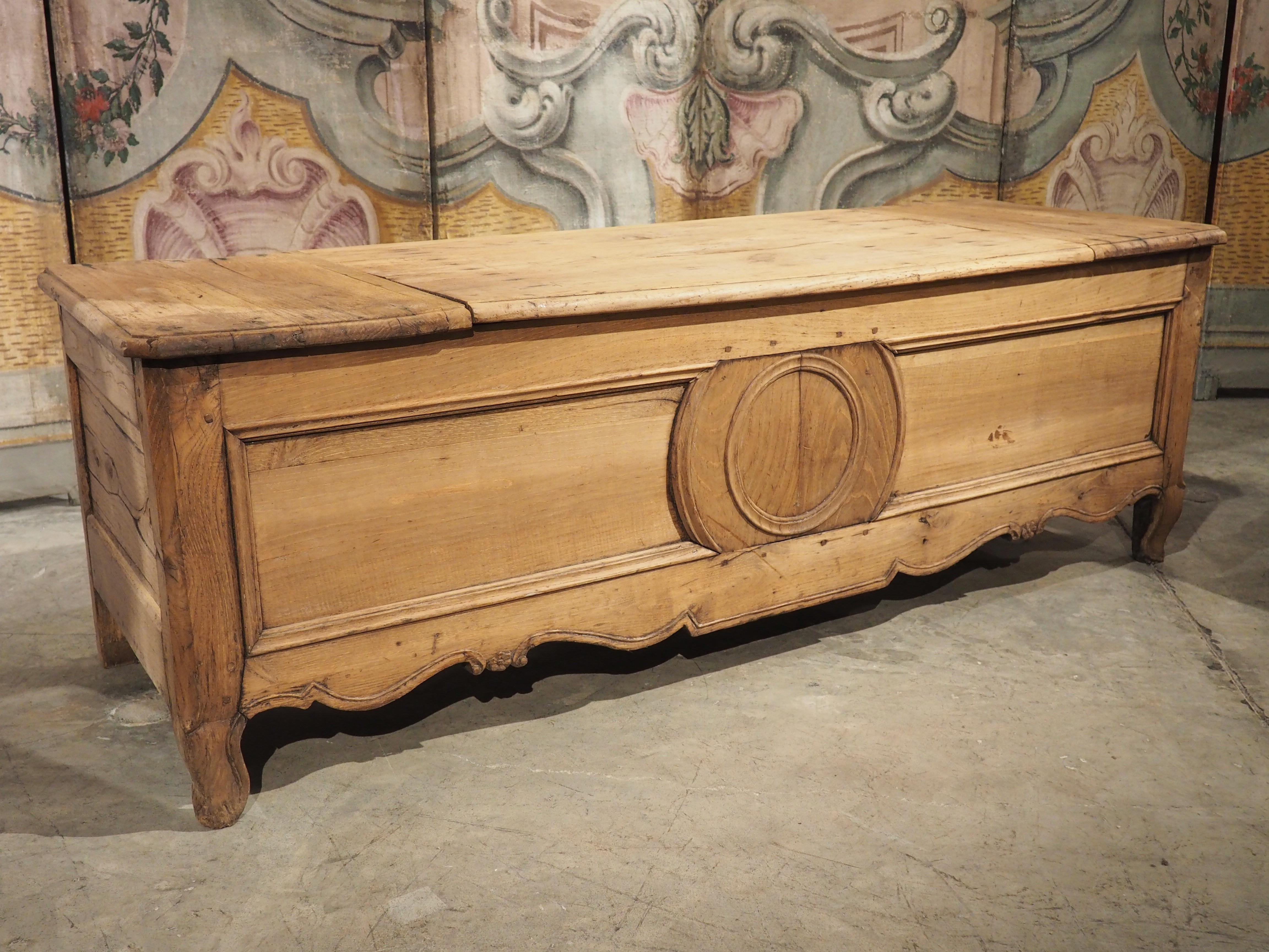 Hand-carved in Brittany, France, circa 1860, this chestnut wood trunk has had the original finish removed at some point. The ornamentation of the trunk is minimal, with the most noticeable carving being the slightly raised concentric roundels on the