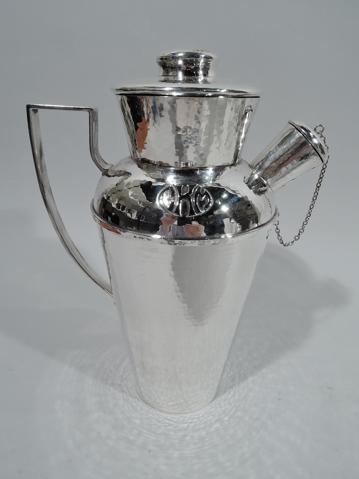Craftsman sterling silver cocktail shaker. Made by Lebolt in Chicago, circa 1920. Tapering and wide-bodied bowl and neck, and stubby spout with chained and cork-lined cap. Cover flat and cork-lined with button finial. High-looping scroll handle. All