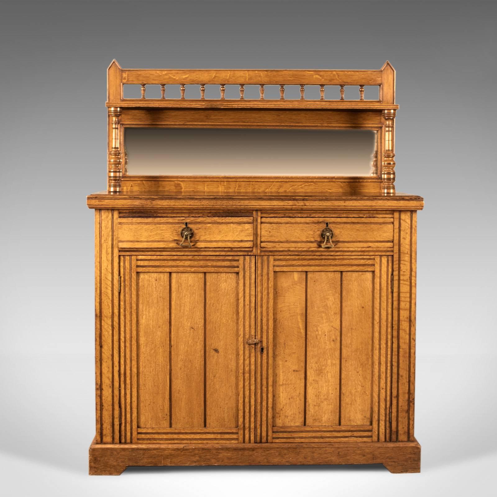 This is an antique chiffonier sideboard, an English, oak credenza buffet cabinet, displaying Gothic overtones and dating to circa 1880.

Of quality craftsmanship in well figured English oak
displaying wisps of medullary rays in the wax polished