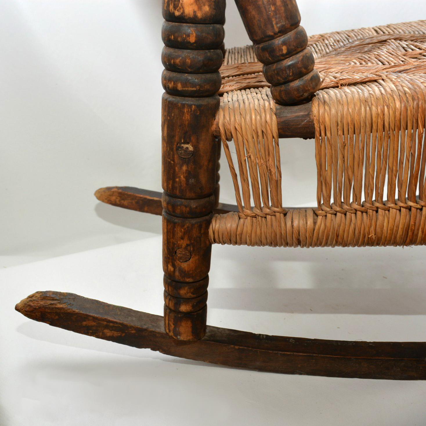 For your consideration an antique child rocker with arm rest. Original vintage patina. Wood frame with seagrass weaving. 

Unmarked. 

Mexico, circa 1930s.

Measures: 21 1/2" H x 21 1/4" D x 14 1/2" W. Seat 10" 

