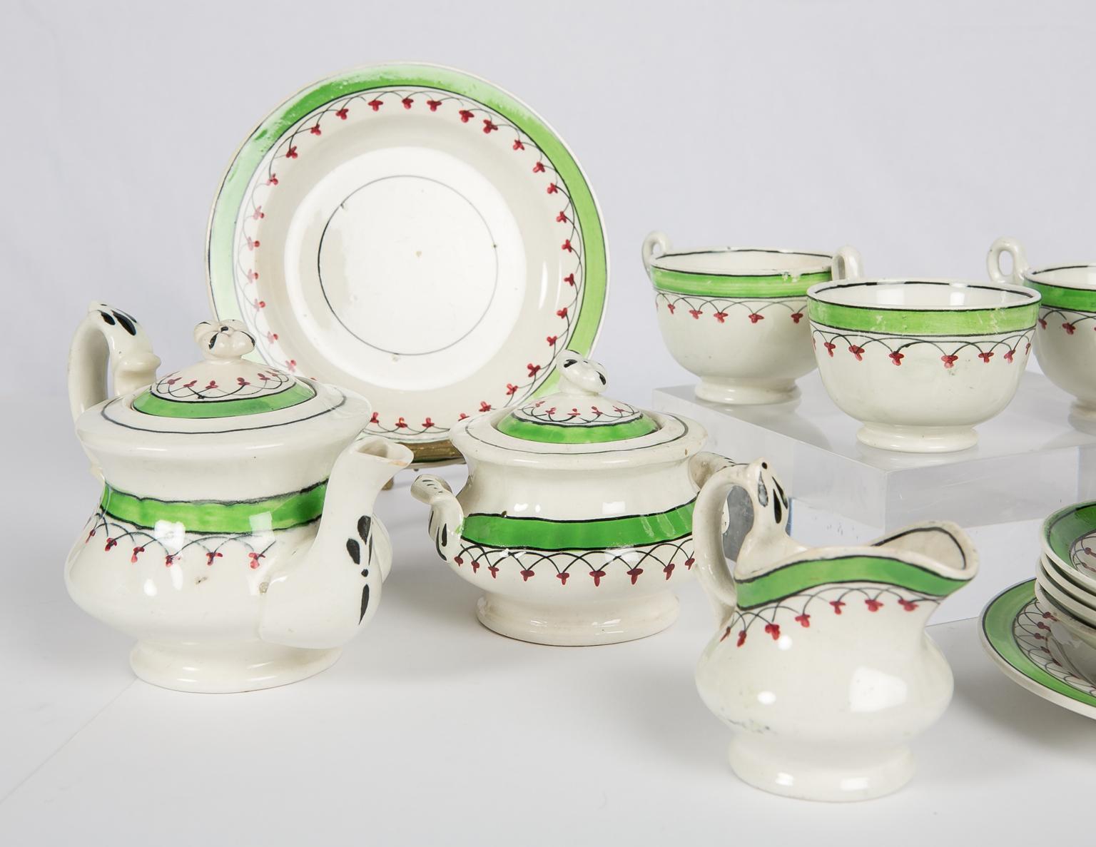 We are pleased to offer this charming antique child's tea set is painted with a lovely English green border, which is enhanced with red berries on a looped design.
The complete set consists of:
A tea pot,
 covered sugar bowl,
a milk pitcher,
 two