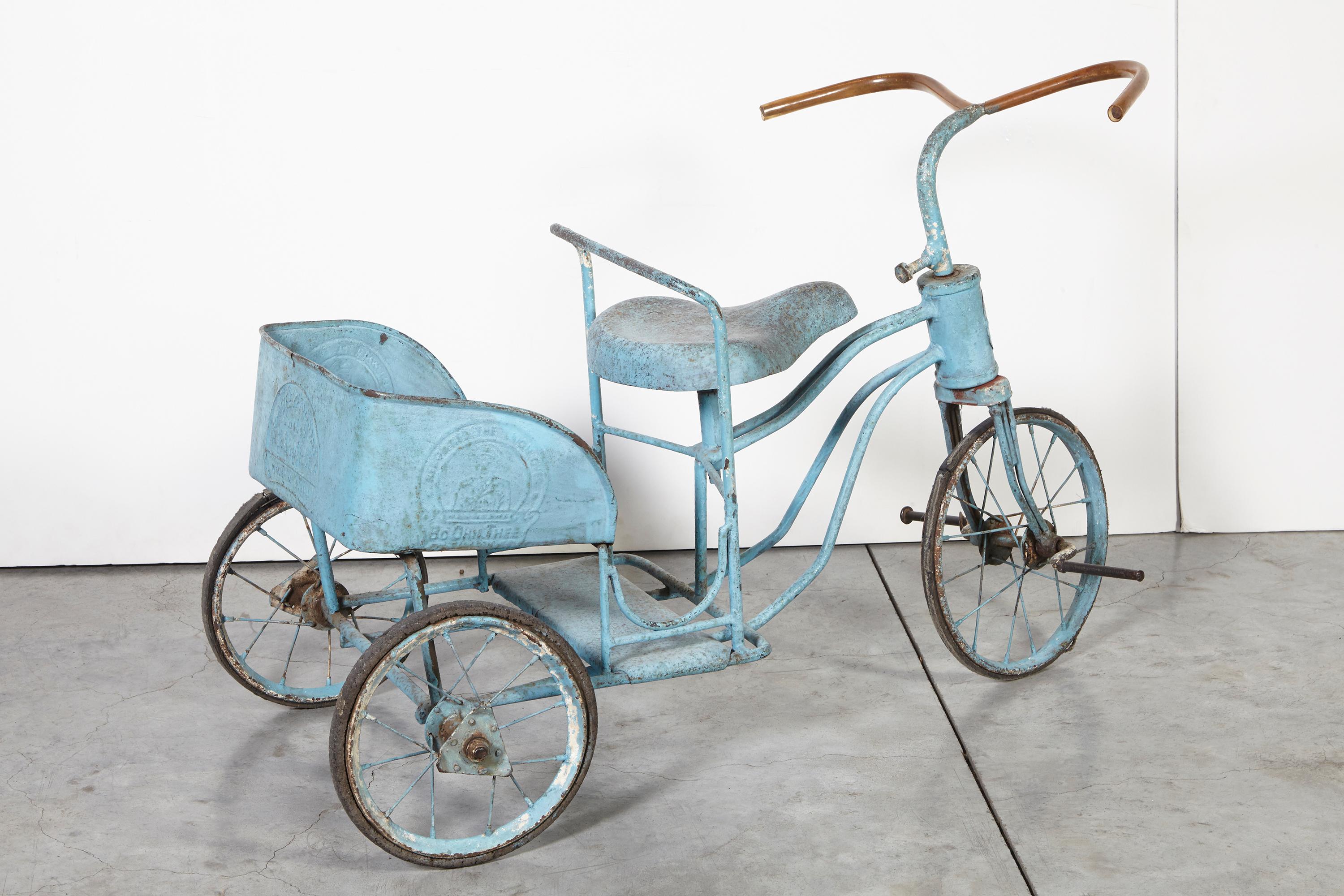 An adorable antique Burmese child's tricycle with parcel carrier and original blue paint. The embossed Burmese characters on the back and side of the carrier add authenticity and interest. An unusual and beautiful object.