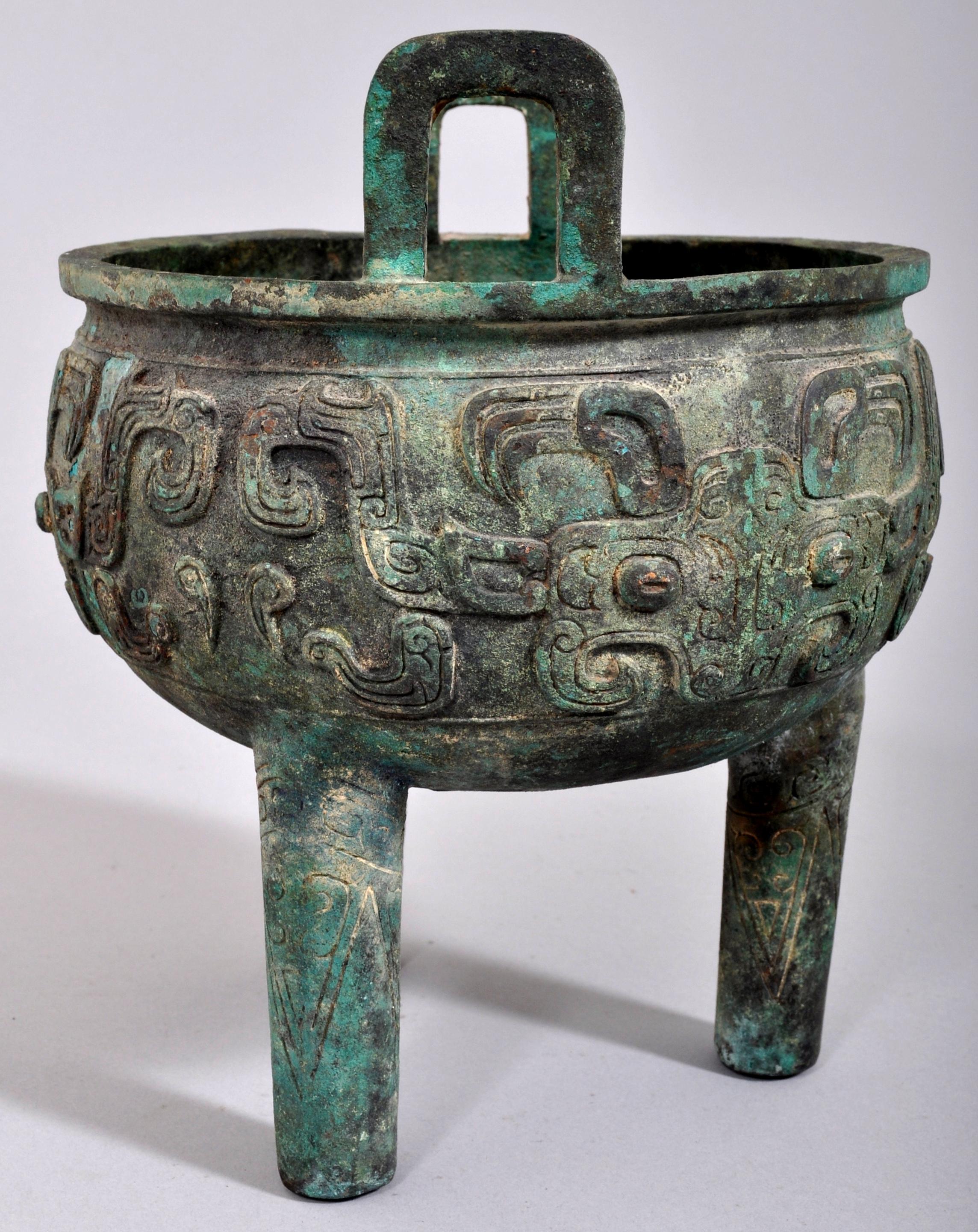Antique 18th-19th century archaic style bronze tripod ding censer. The censer purporting to be a Ding from the late Shang Dynasty (circa 1600-1046 BCE), but more likely an 18th or 19th century homage to antiquity. The ding of circular form and