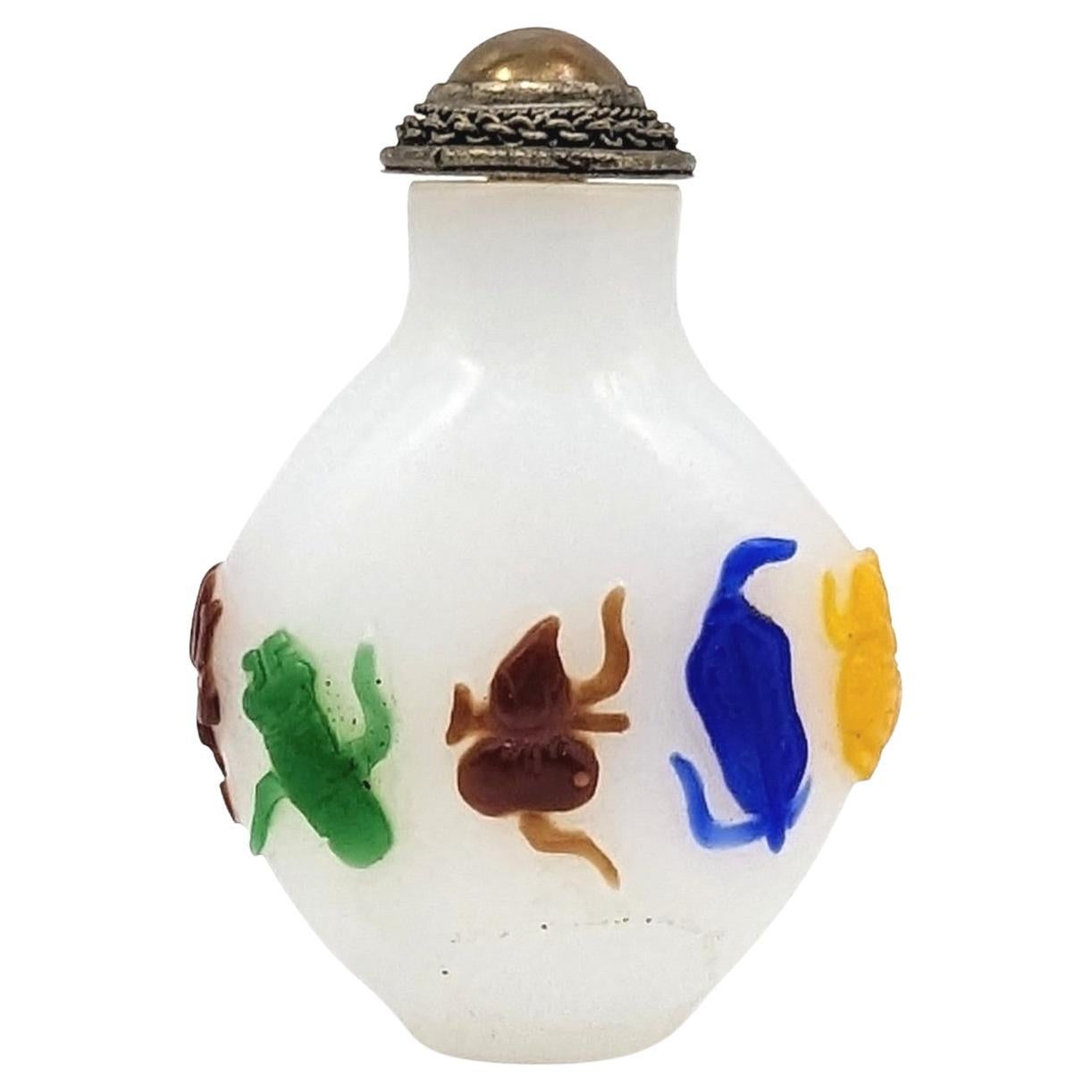 Antique Chinese multi-color (5) glass overlay snuff bottle with eight treasures finely carved in low relief in 4 colors on pale white ground

19th Century, Qing Dynasty