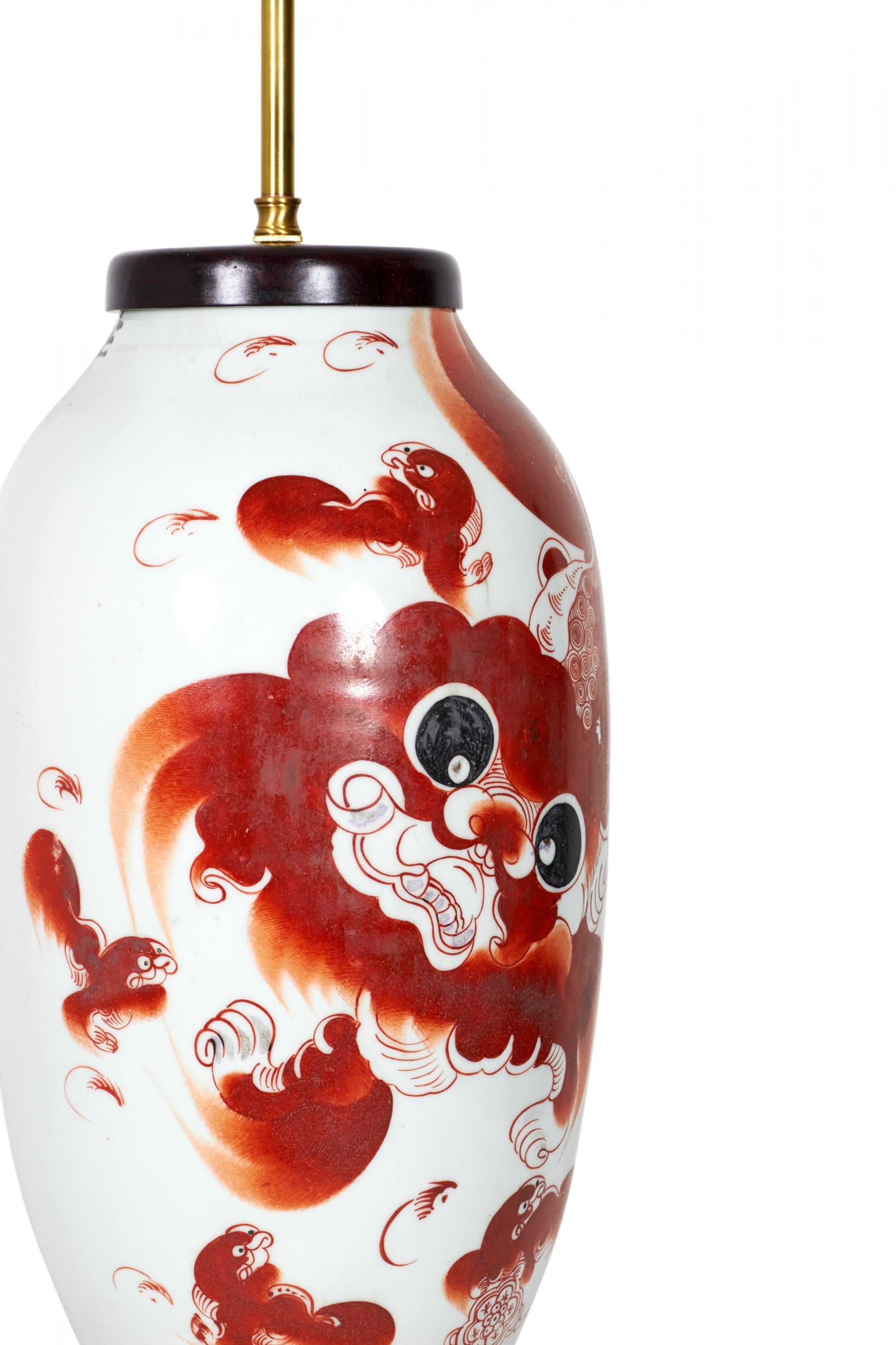 Lampe de table chinoise ancienne fabriquée à partir d'un vase en porcelaine monté avec du bois et des ferrures en laiton en guise de lampe, avec un motif de lion Taishi Shaoshi rouge alun sur un fond gris-beige. (Lampe similaire : NWL2722)

Livré