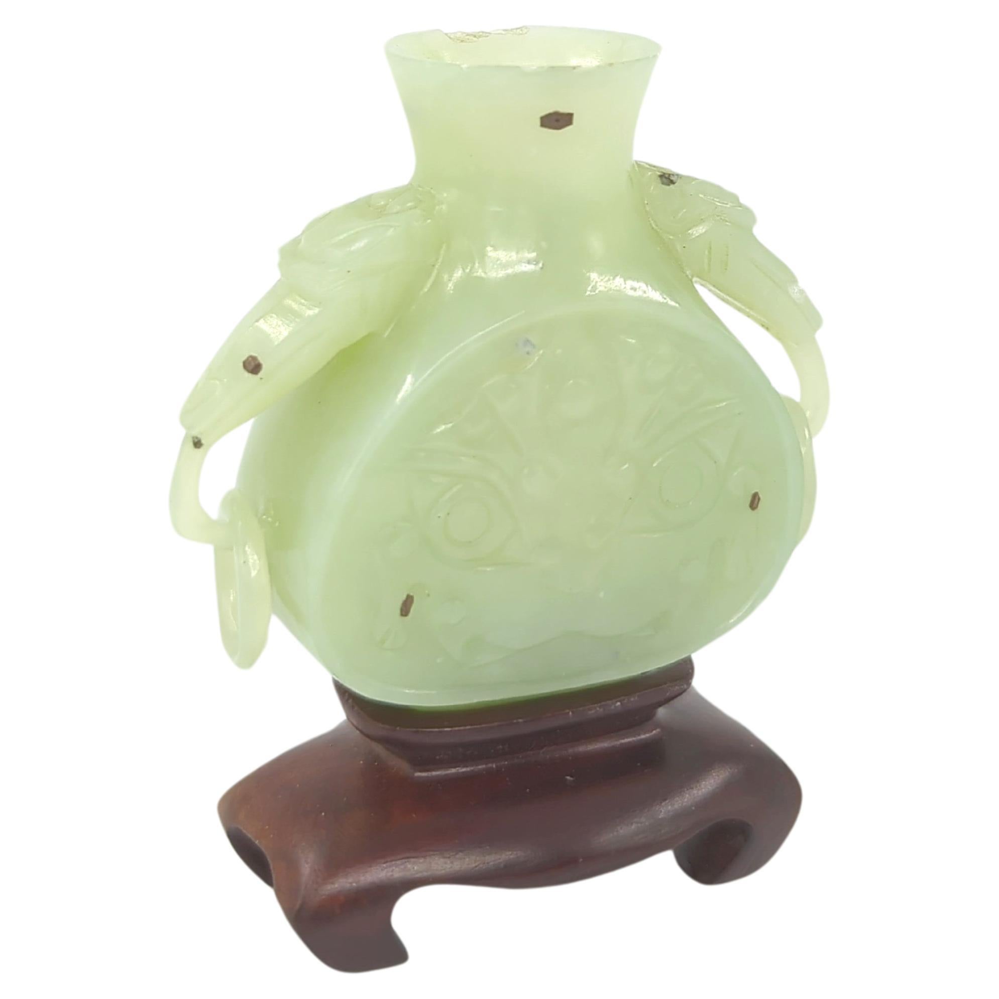 This exquisite 19th-century Qing Dynasty celadon jade miniature vase is a masterwork of Chinese craftsmanship. The vase features intricately carved beast handles, each adorned with free-moving rings, adding a layer of complexity and artistry to the