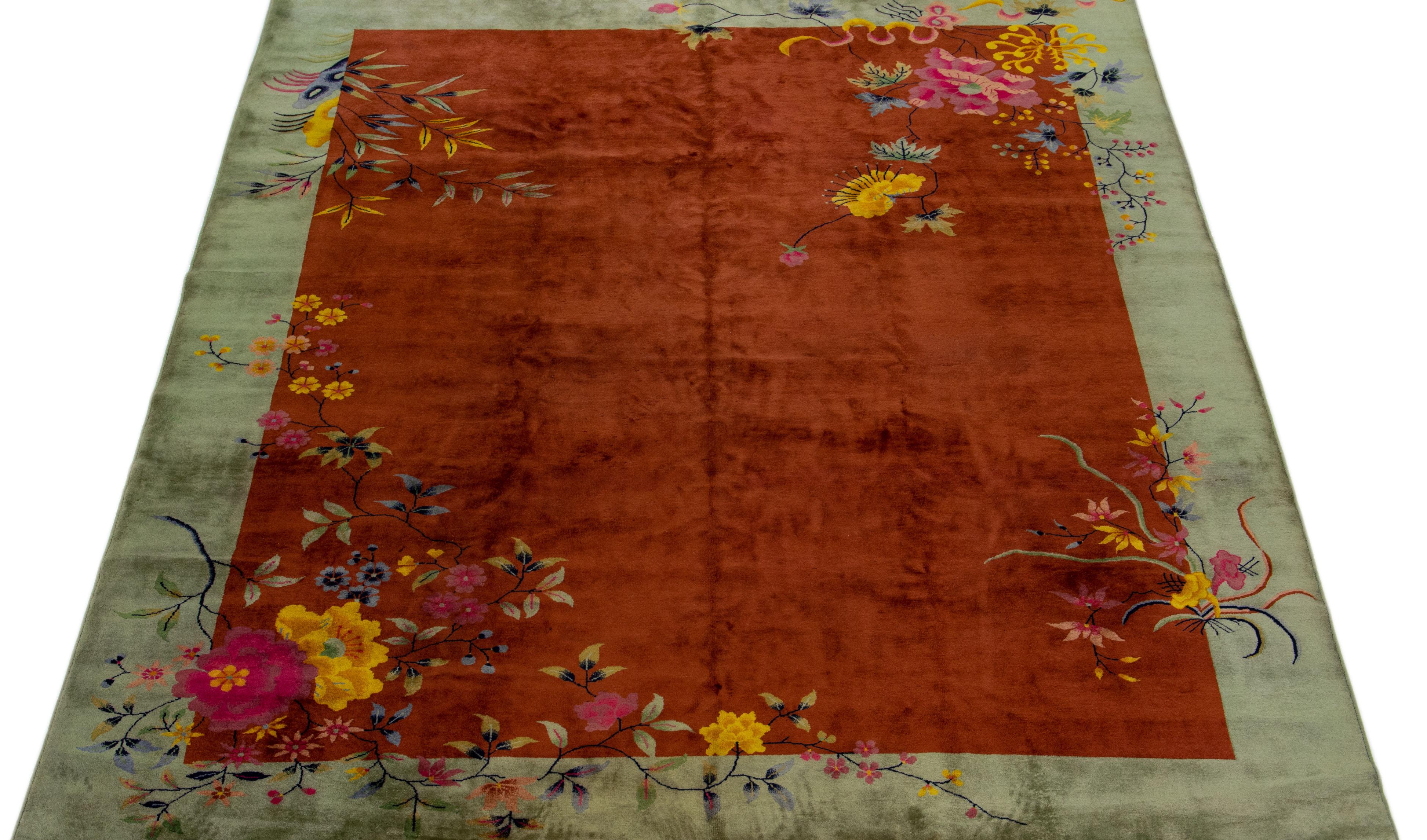 Beautiful antique Art Deco hand-knotted wool rug with a brown color field. This piece has a green frame with multicolor accents in a gorgeous traditional Chinese floral design. 

This rug measures: 8'10