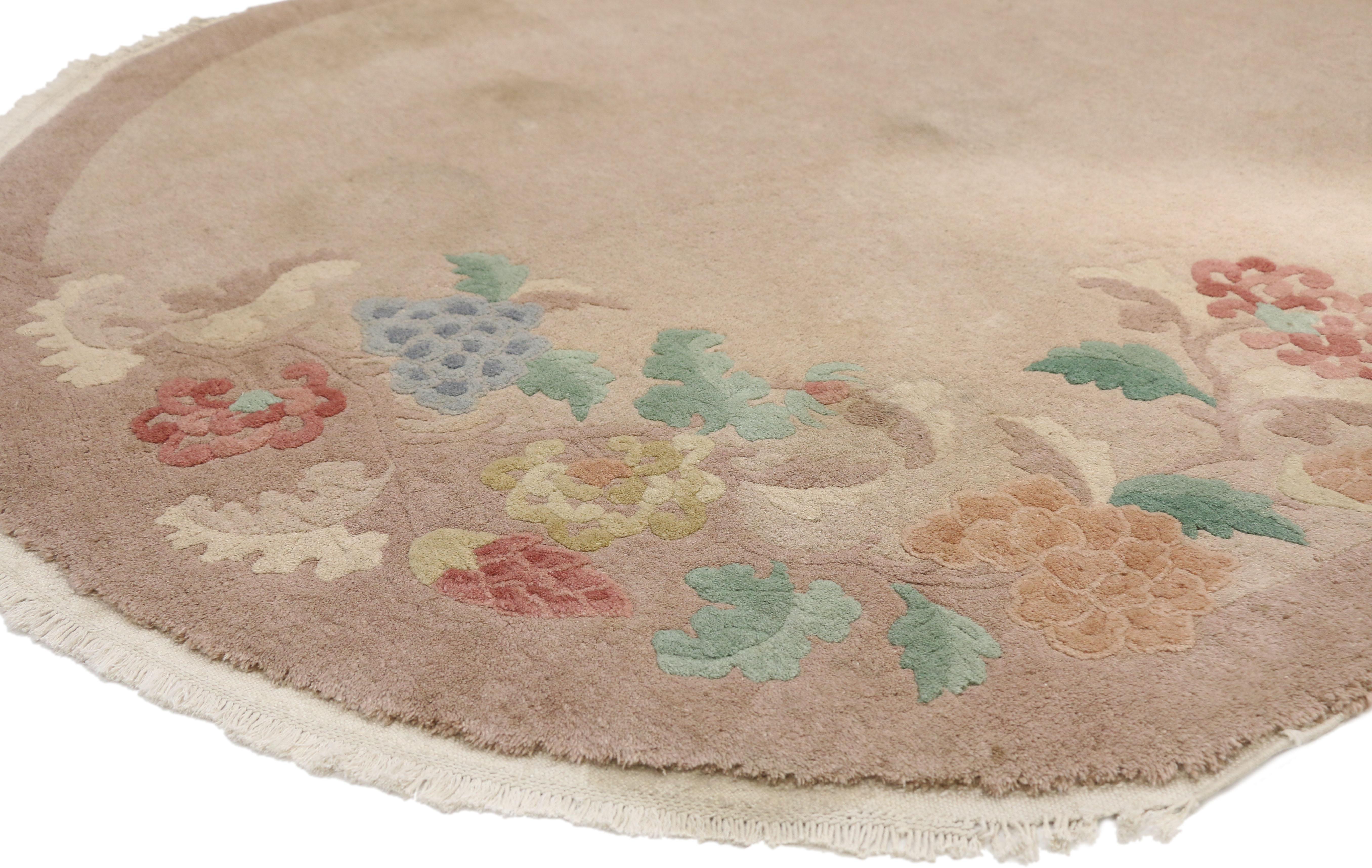 77328 antique Chinese Art Deco oval rug with traditional chinoiserie style. This hand knotted wool antique Chinese Art Deco rug features a plain neutral field and border festooned with three scrolling floral vines along the edges of the composition.