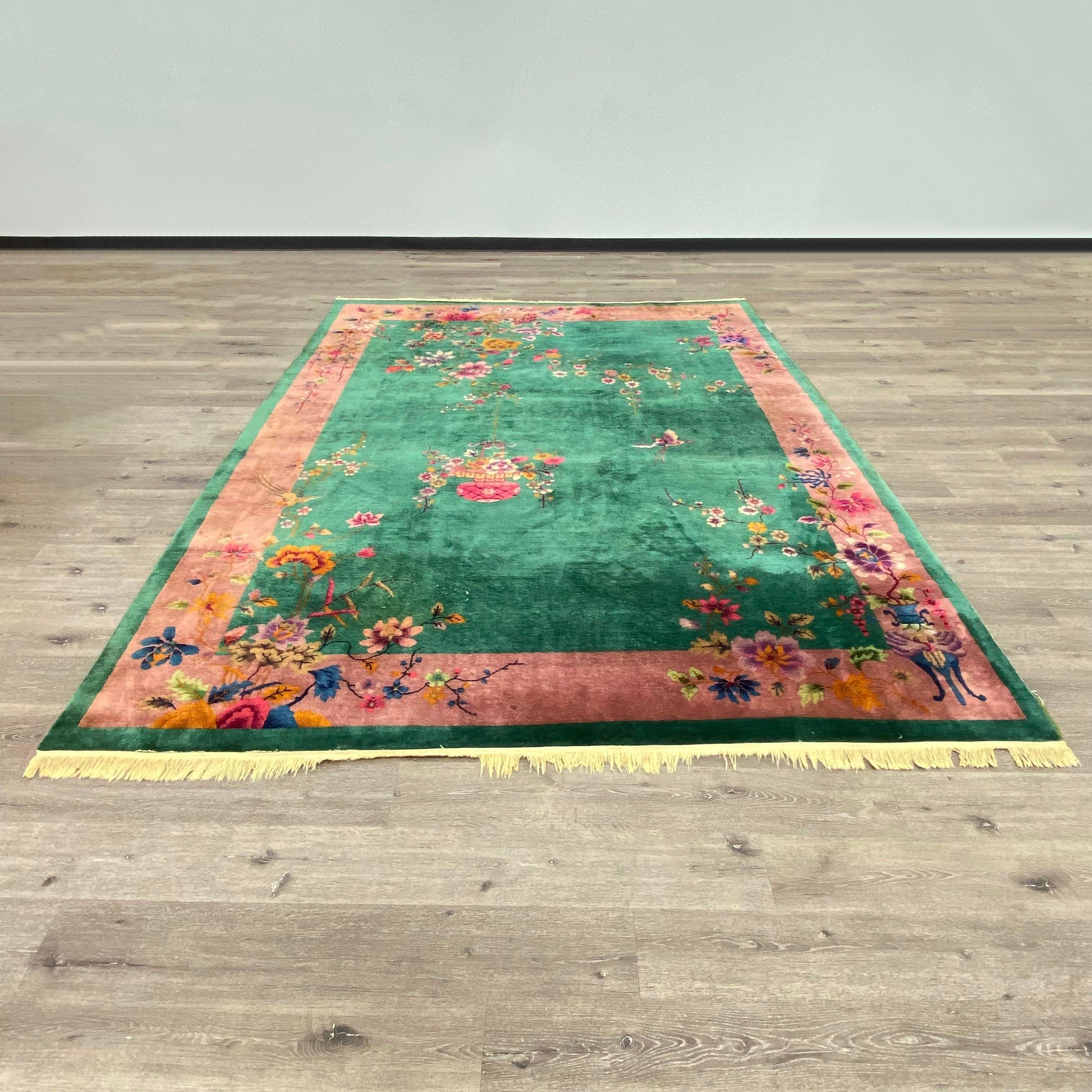 Antique Chinese Art Deco wool rug in stunning teal, pink, blues, and green with a floral motif. Floral arrangements throughout and with birds and a butterfly mid flight. Teal green rug with a pink border and florals sprinkled throughout. Measures: