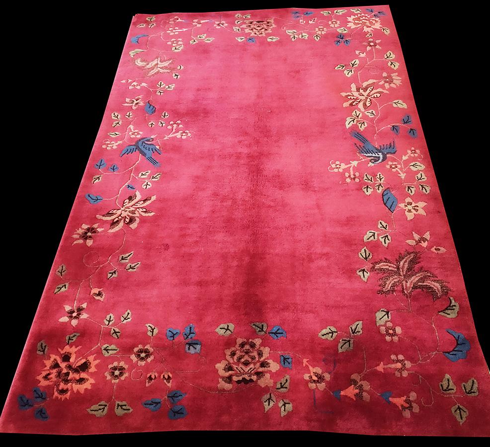 This deep rose 1920’s rug from Tientsin(Tianjin)in NE China has an open field with birds perched in a leafy vine scroll border with occasional large tree peonies. There is no inner bounding line and one almost expects the winery to spill into the