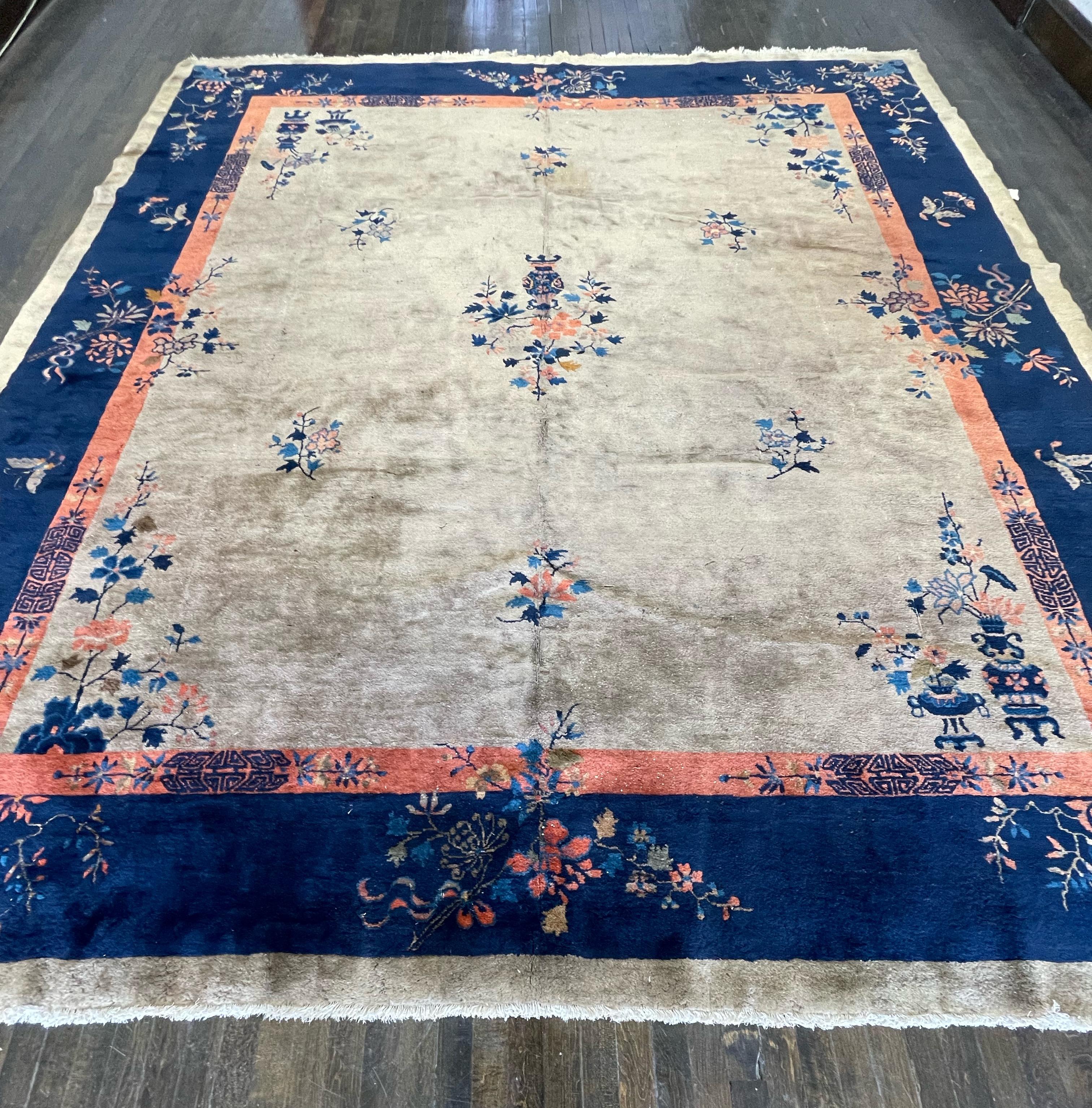 This carpet is hand knotted in China. The high quality wool and all organic dyes has made this carpet age well with fantastic patina. The field has a soft tan with beautifully simple motifs that are well spaced that goes well with indigo blue
