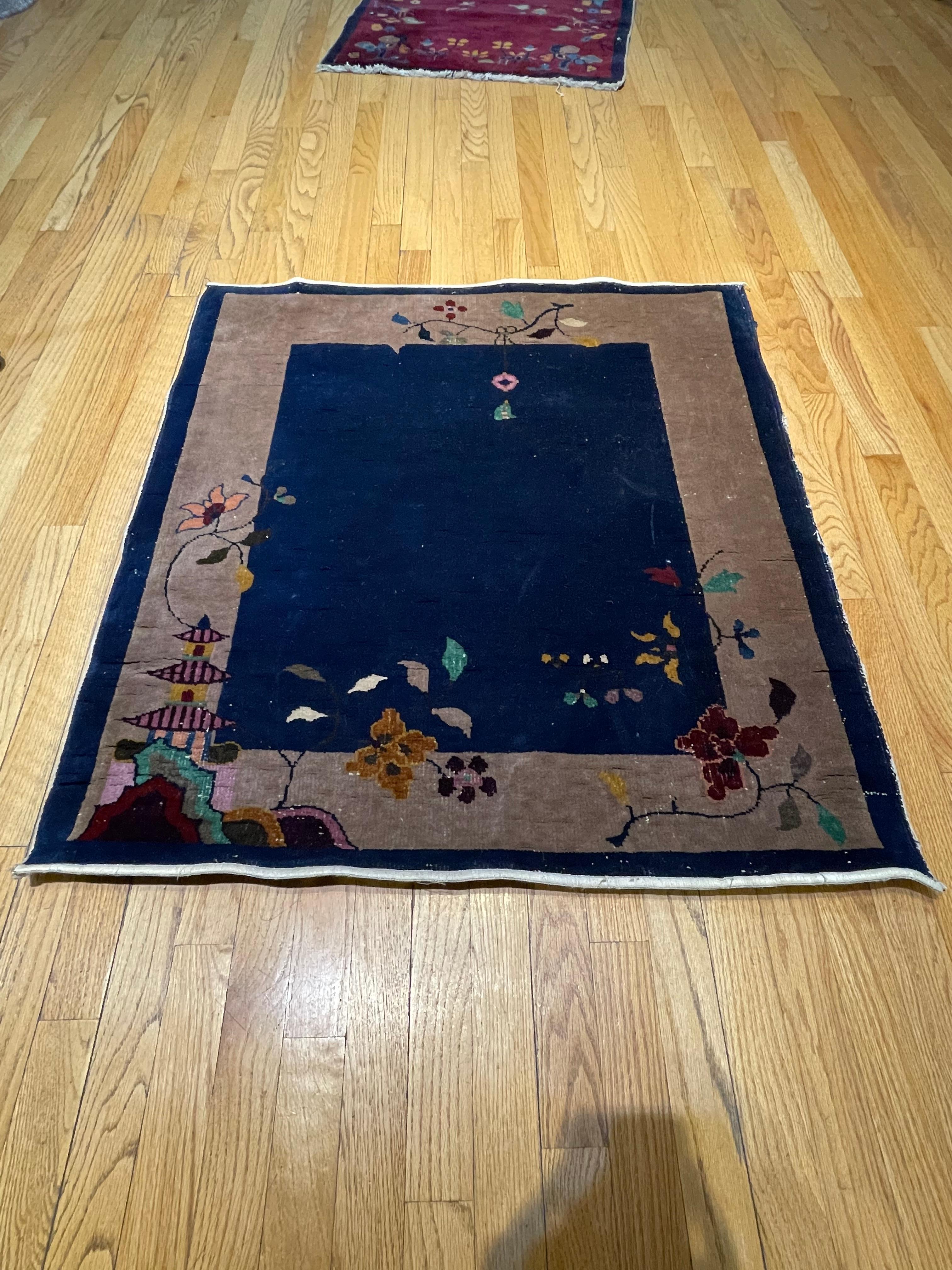 This very rare antique rug is hand woven in china circa 1920. With indigo blue field and a taupe border, decorated with red/maroon plum blossom and in one corner with an emperor palace, a sign of wealth. In mint condition there are no restorations