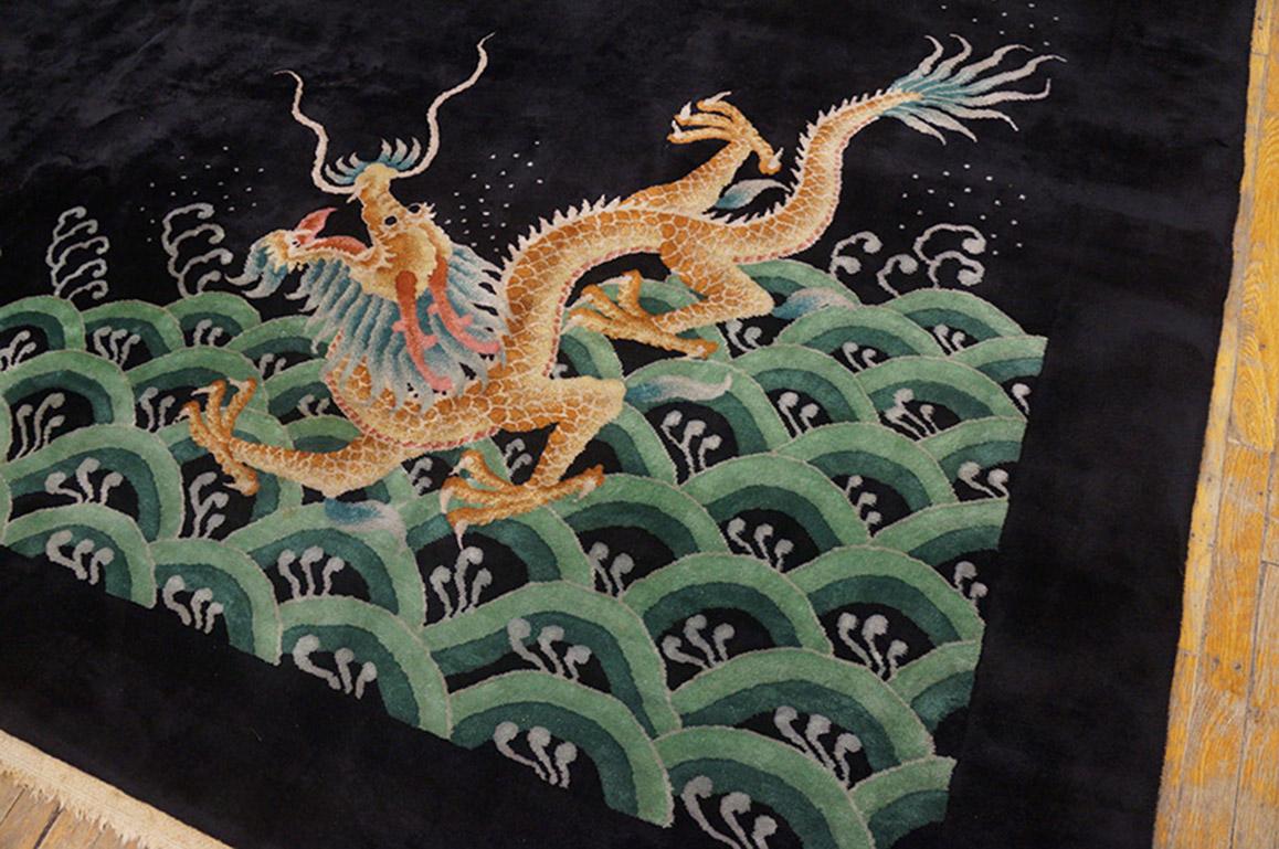 Un dragon terrestre/aquatique s'élève de vagues stylisées tandis qu'un dragon céleste descend de nuages à verticilles de champignons avec deux perles enflammées dans les zones unies de ce tapis Art déco noir sur noir. Souvent, dans l'art chinois,