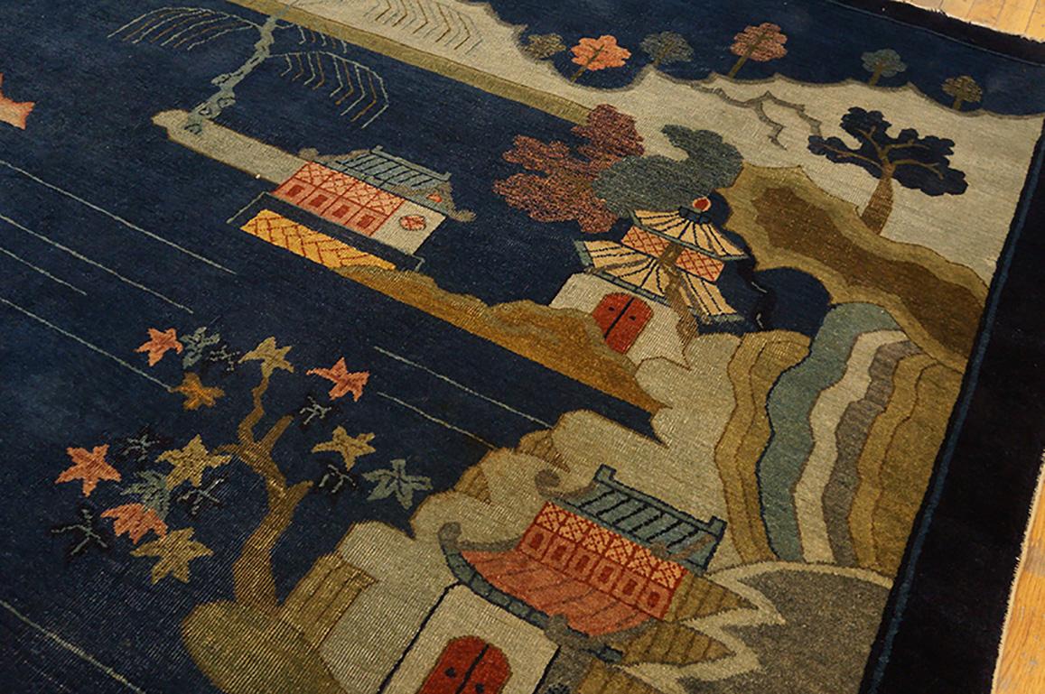 Chinese pictorial landscape carpets are derived from hanging scrolls and often, as here, a river broadly winds from bottom to top, crossed by a rustic bridge, flanked by cliffs with picturesquely bent trees and with a goodly mix of houses, pagodas