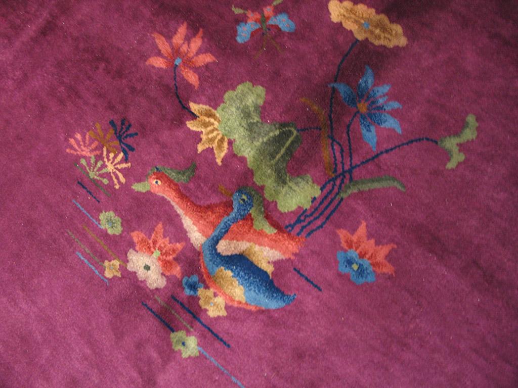On each of the four border sides are facing pairs of feng-hung (phoenix) birds with long wavy tail feathers, set around a paeony palmette. A black wiry arabesquerie supports the birds. The rose pink field shows a broken floral stem inner oval