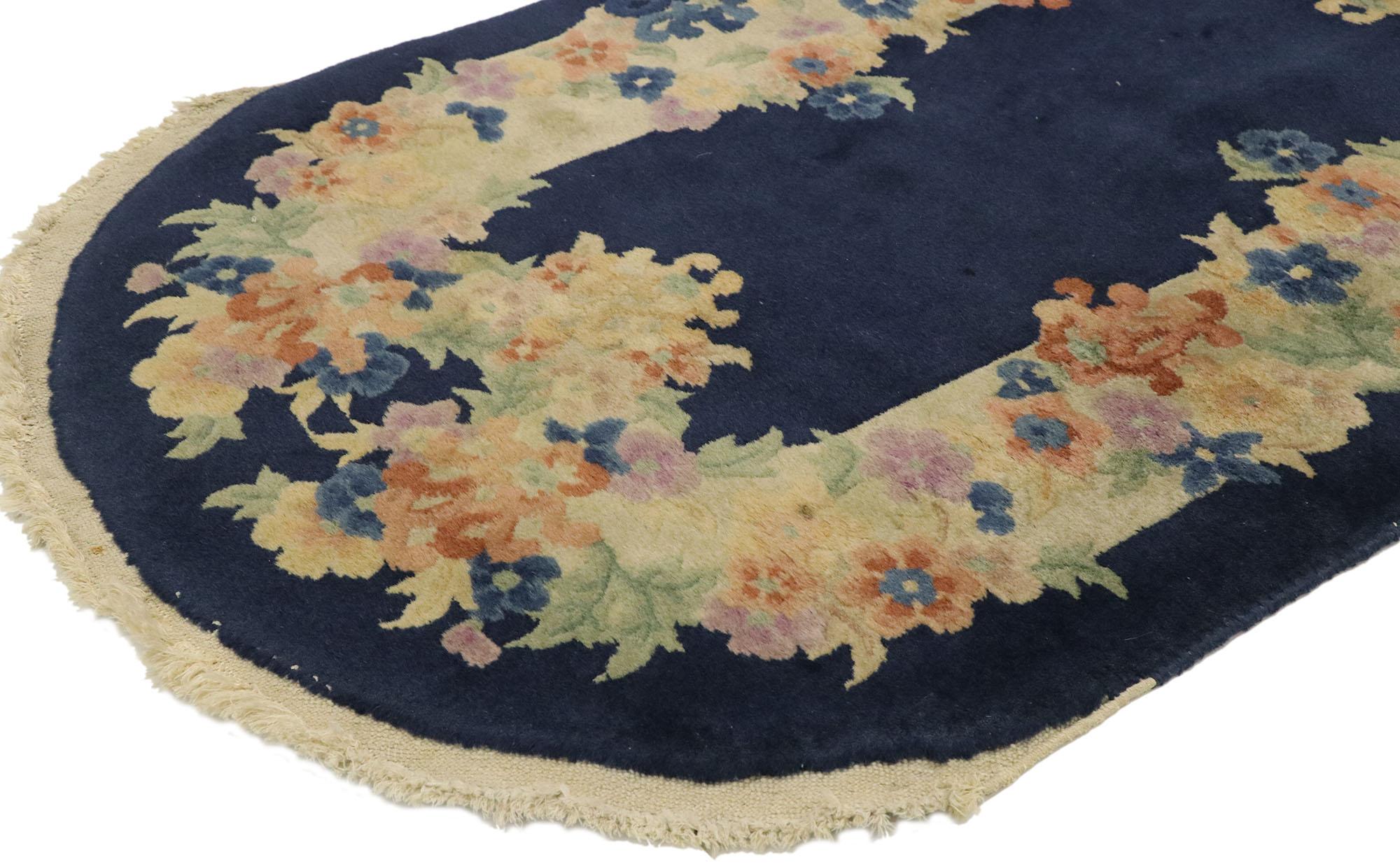 77463, alfombra ovalada antigua china de estilo Art Déco con estilo chinoiserie romántico. Esta antigua alfombra china Art Decó de lana anudada a mano presenta un campo azul marino noche y un borde en contraste adornado con enredaderas florales que