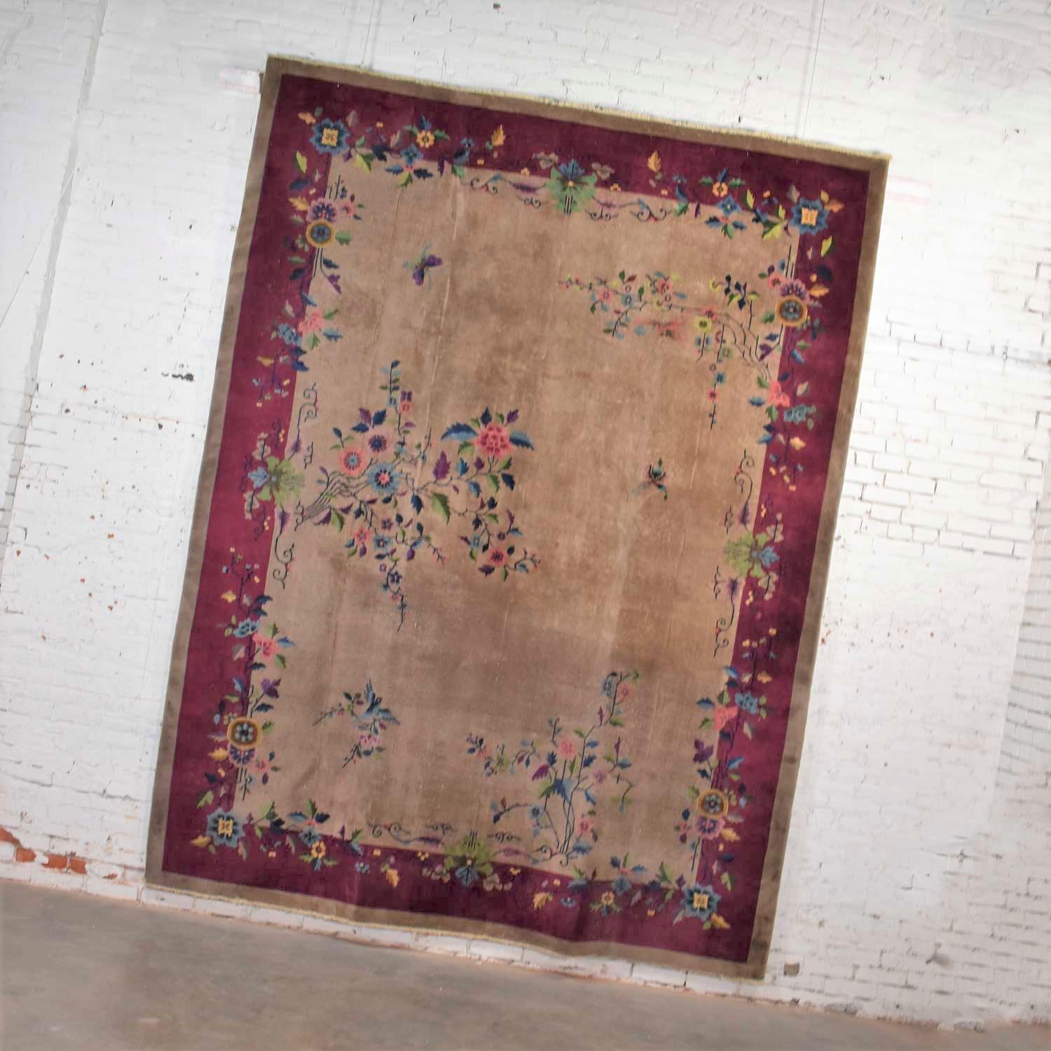 Handsome vintage wool 8’8” x 11’4.5” handmade Chinese Art Deco rug in a gorgeous soft taupe ground with a cranberry or magenta border and jewel tone Art Deco floral design. It is in fabulous vintage condition. We have cleaned the rug thoroughly;