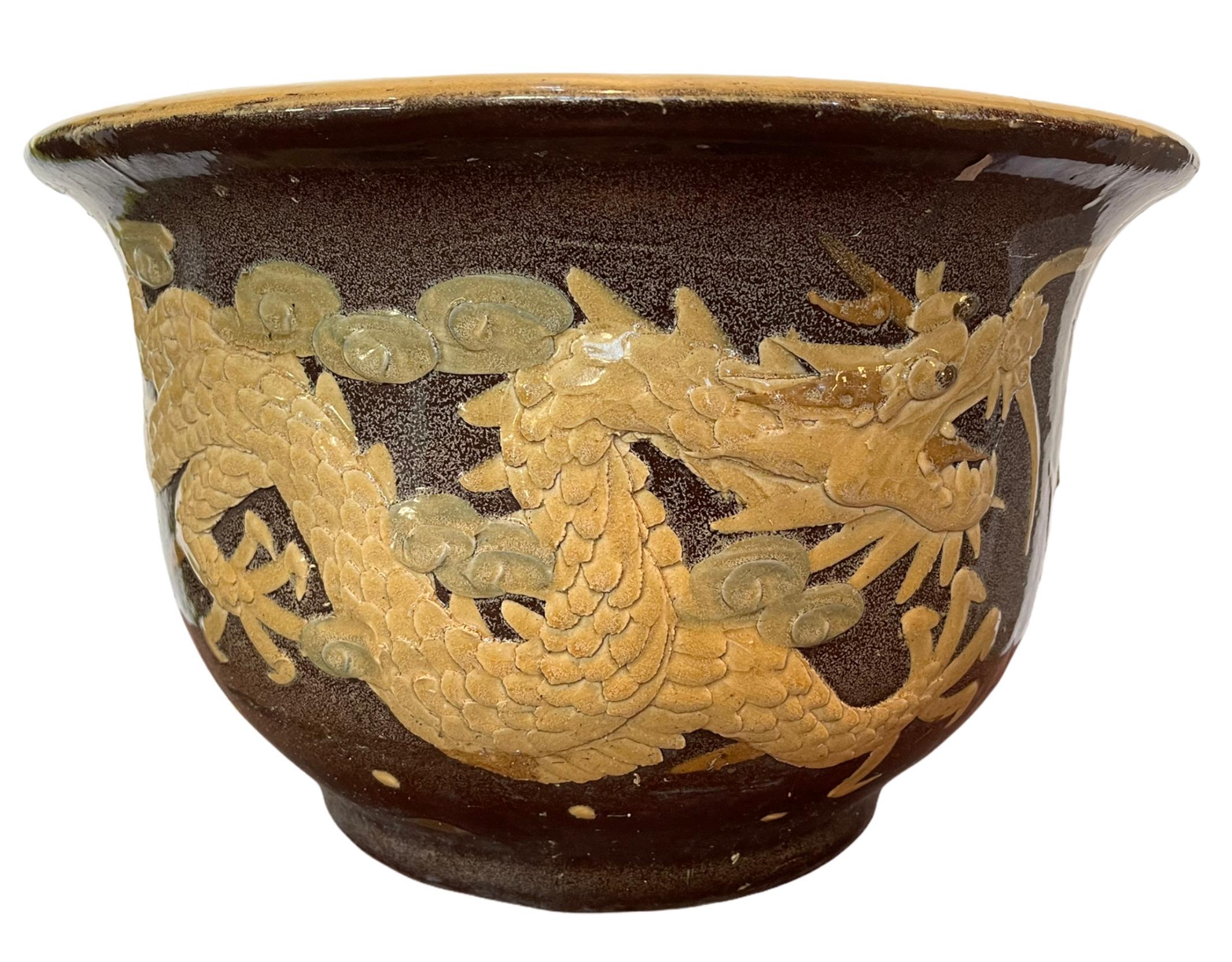 Late 19th century black egg Chinese art pottery pot featuring an Asian dragon along the front. These Pots over a 120 years were used for the storage of black 