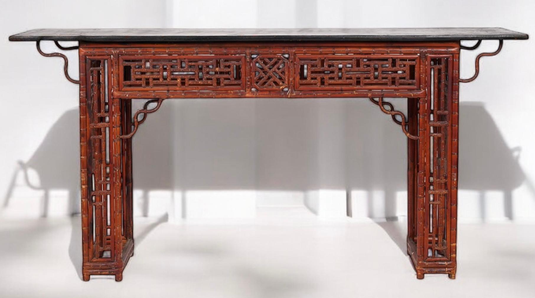This is a 19th century Chinese bamboo alter table with ebonized wood top. It has elaborate scrolled fretwork. It has age appropriate wear. 

Shipping is running two to five weeks. 