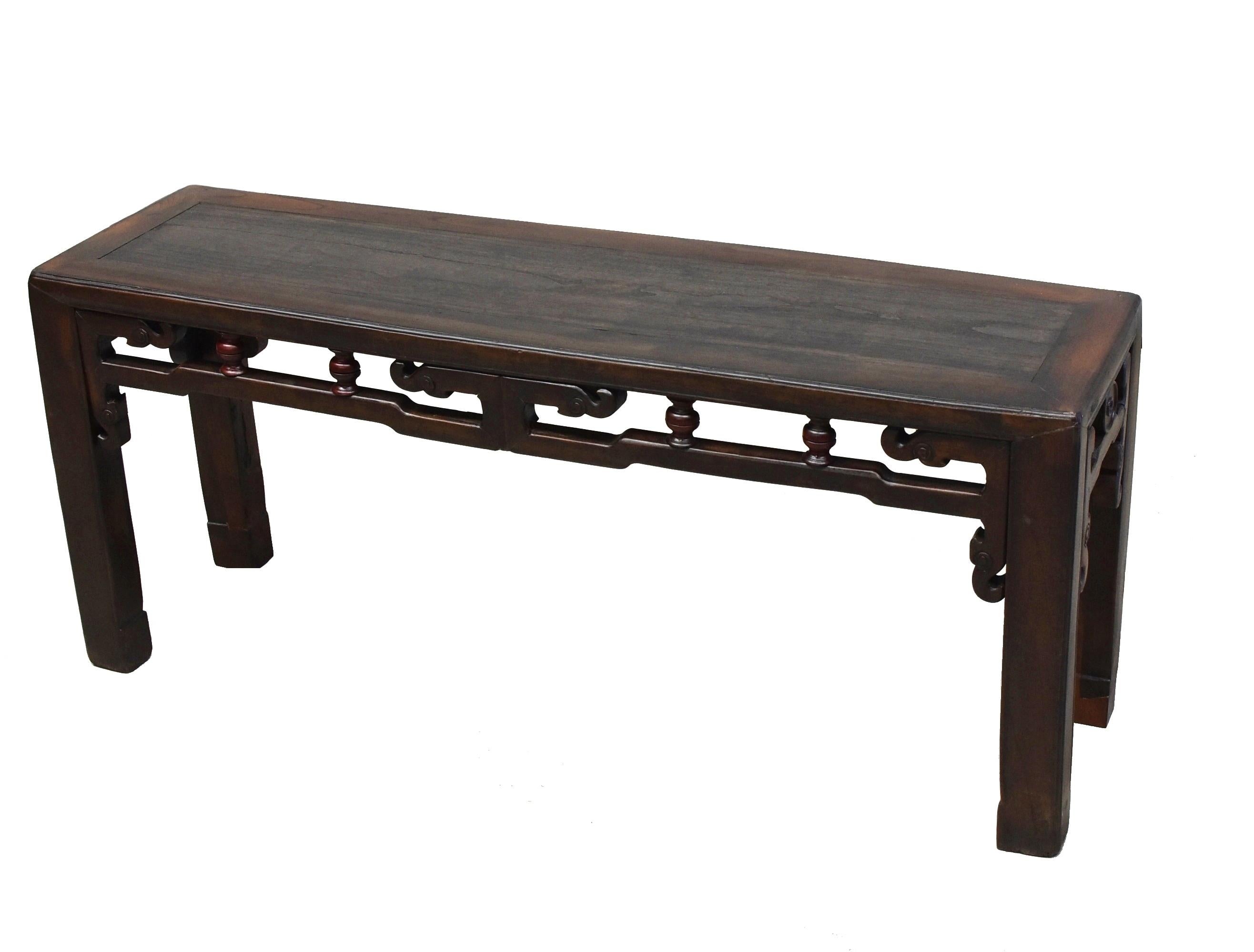A solid wood antique Chinese spring bench. Such a bench was made in the region south of China's Yangtze river. It is sturdy and multi-functional, often used both as a seat and a table. The bench is finished on all sides, featuring the carved,