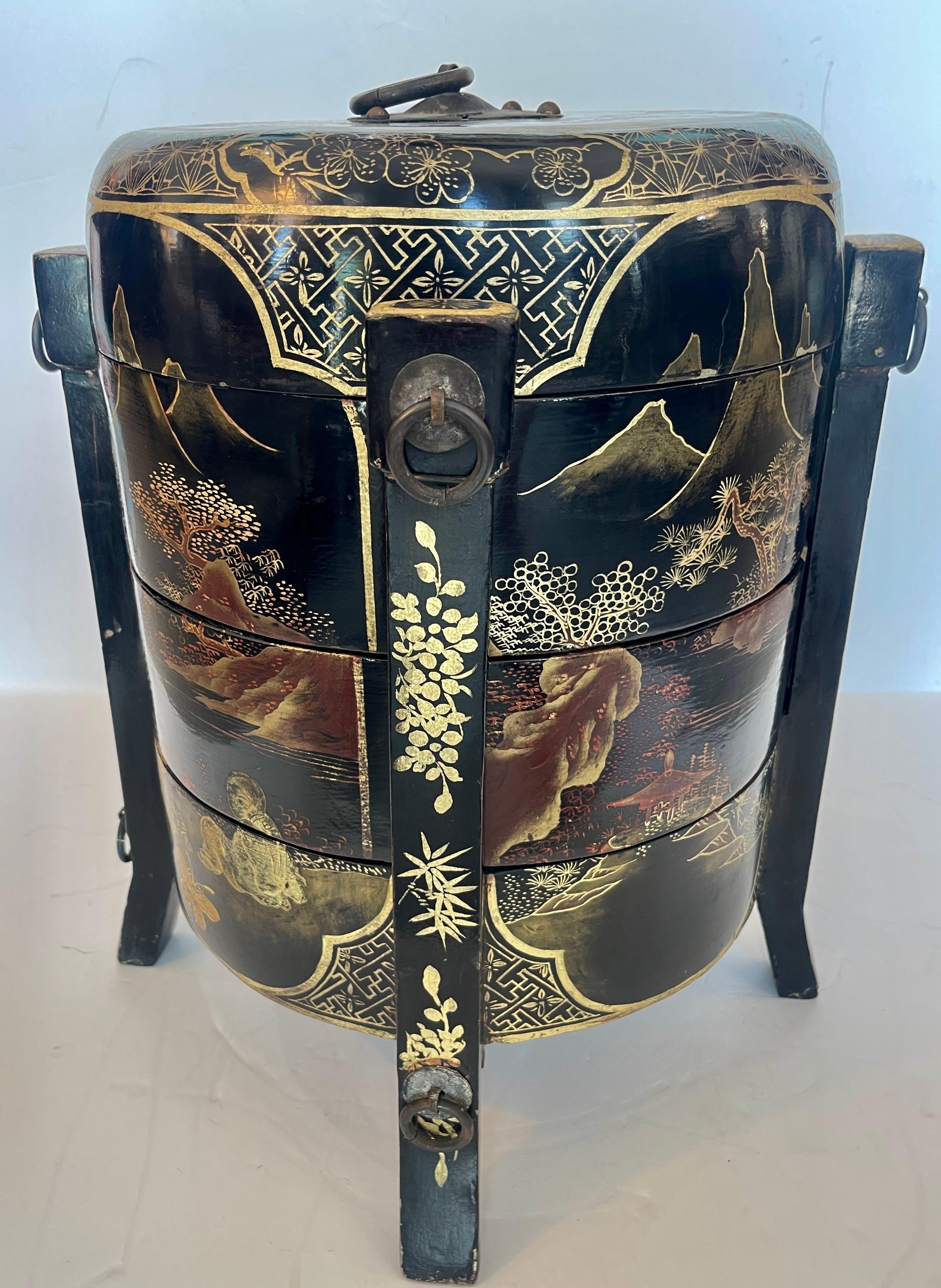 Questo contenitore cinese o giapponese a tre livelli in lacca, forse un cesto nuziale o un contenitore. 
Si tratta di un contenitore a più livelli, realizzato in legno e rifinito con lacca nera e intricate scene paesaggistiche tradizionali dorate