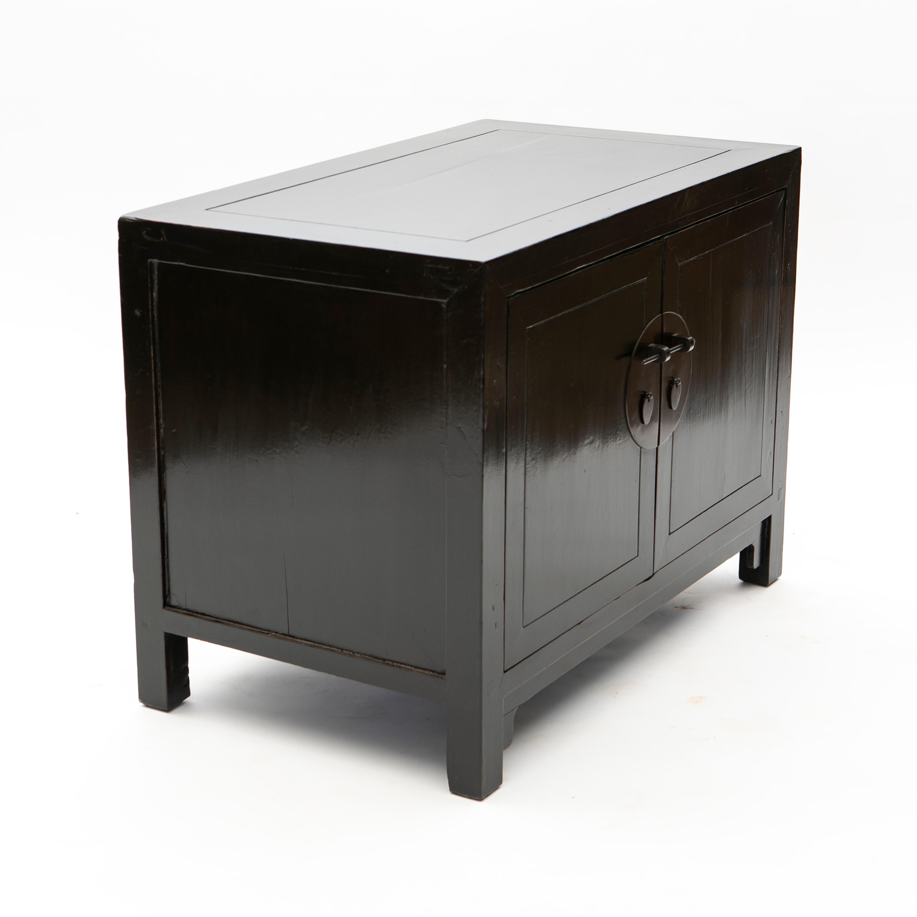 Chinese art deco elmwood sideboard having black lacquer.
A double door with large round metal central plate and pull handles. 

China approx. 1920