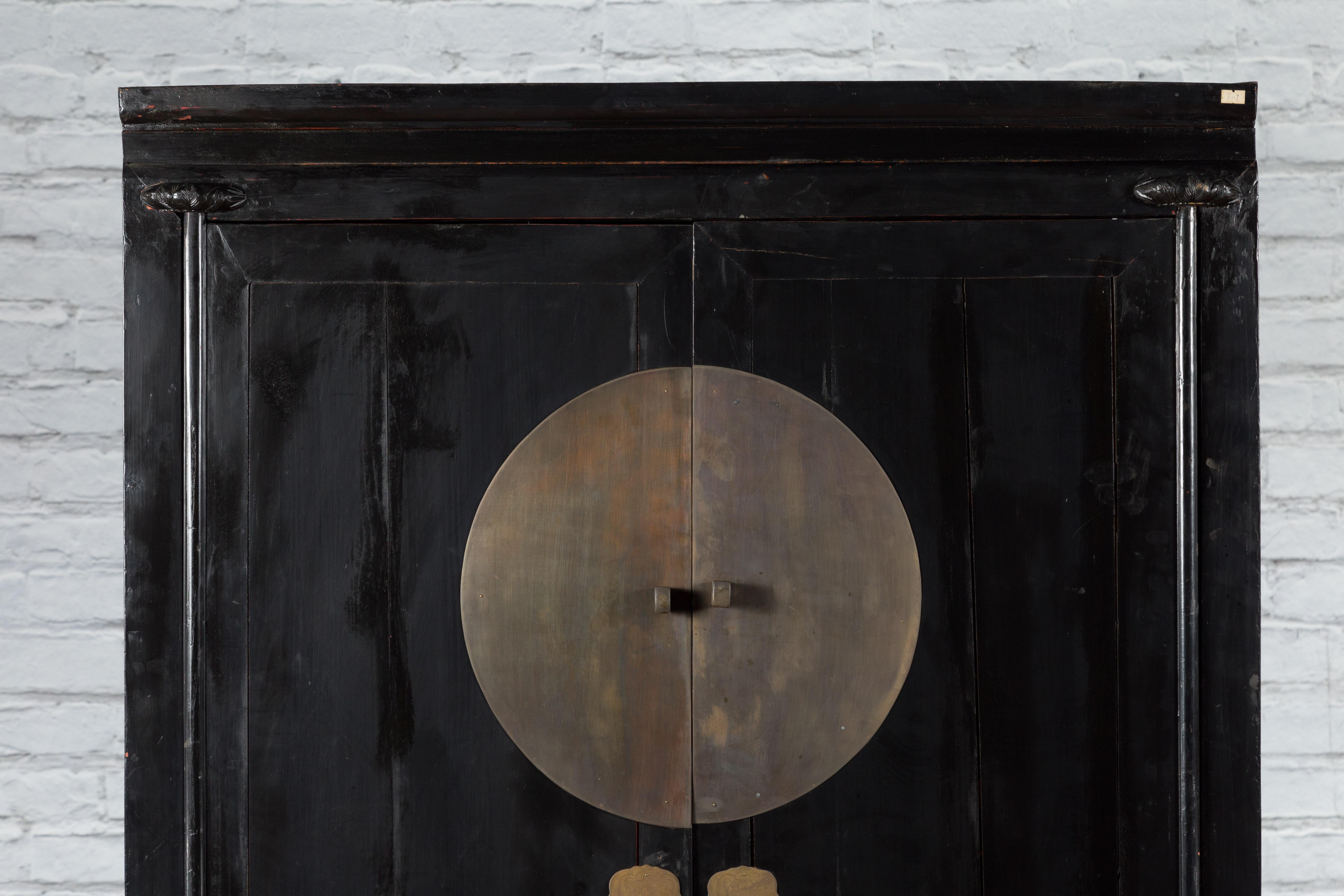 Carved Antique Chinese Black Lacquer Wedding Cabinet with Oversized Brass Medallion For Sale