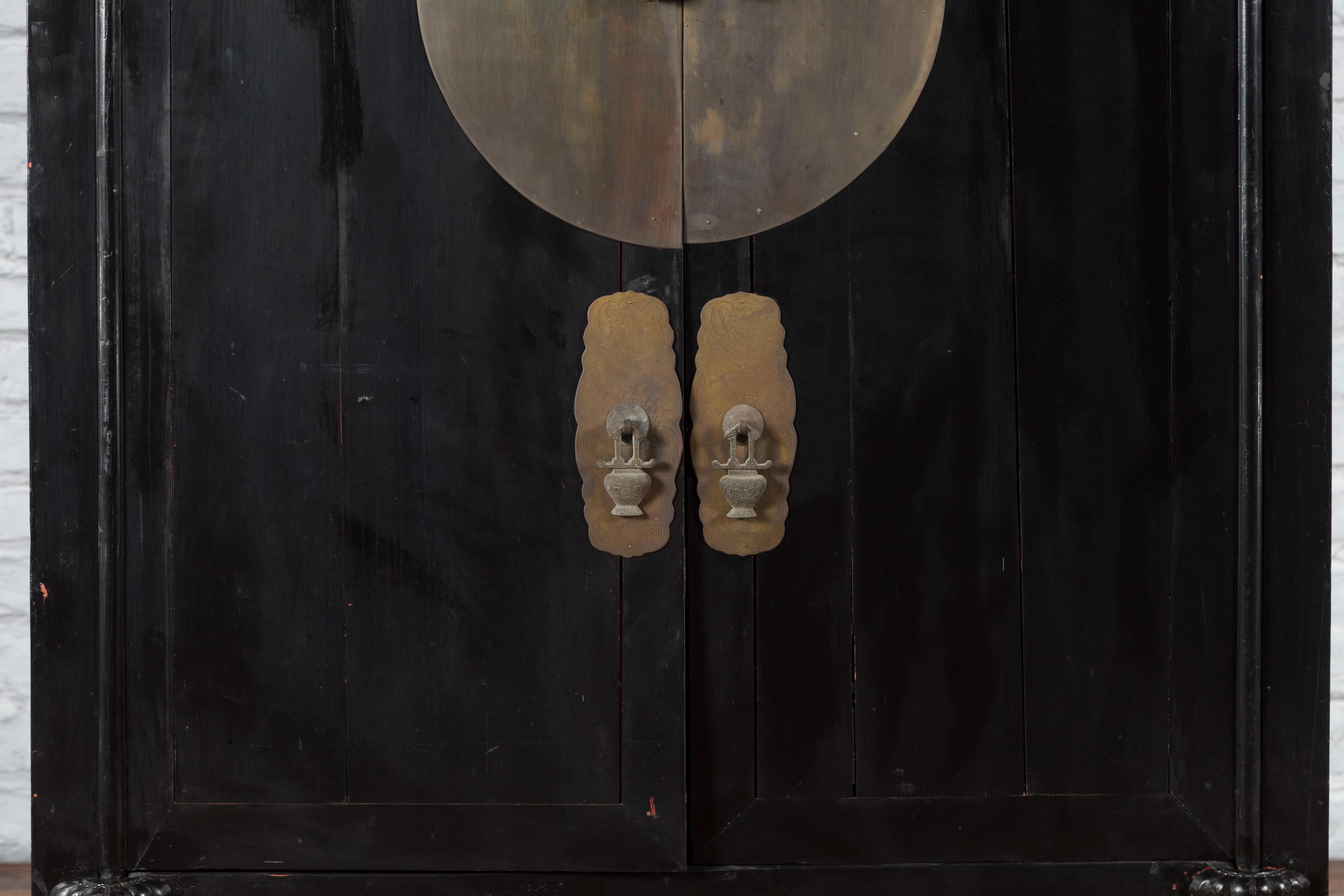 20th Century Antique Chinese Black Lacquer Wedding Cabinet with Oversized Brass Medallion For Sale