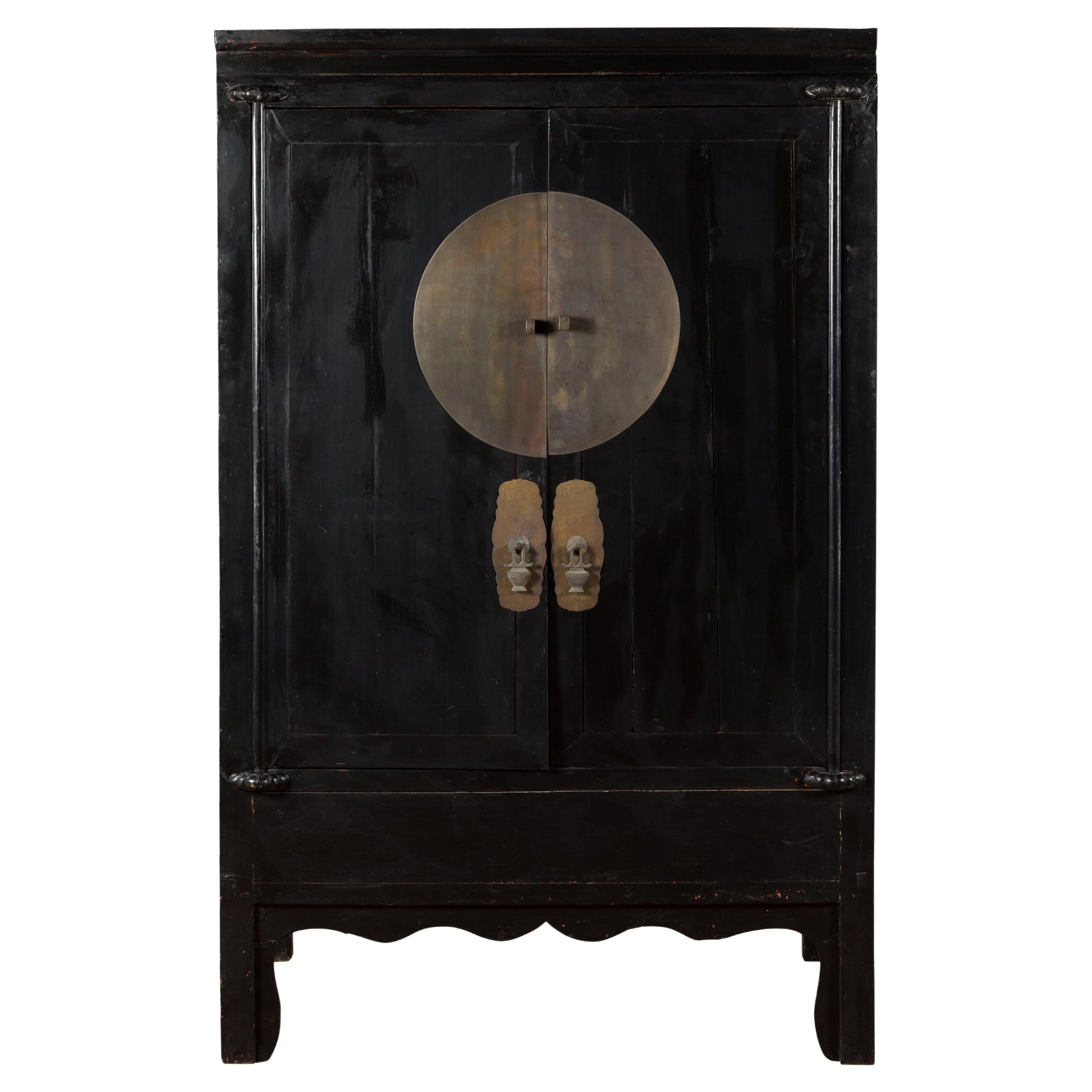 Ancienne armoire de mariage chinoise en laque noire avec médaillon en laiton surdimensionné