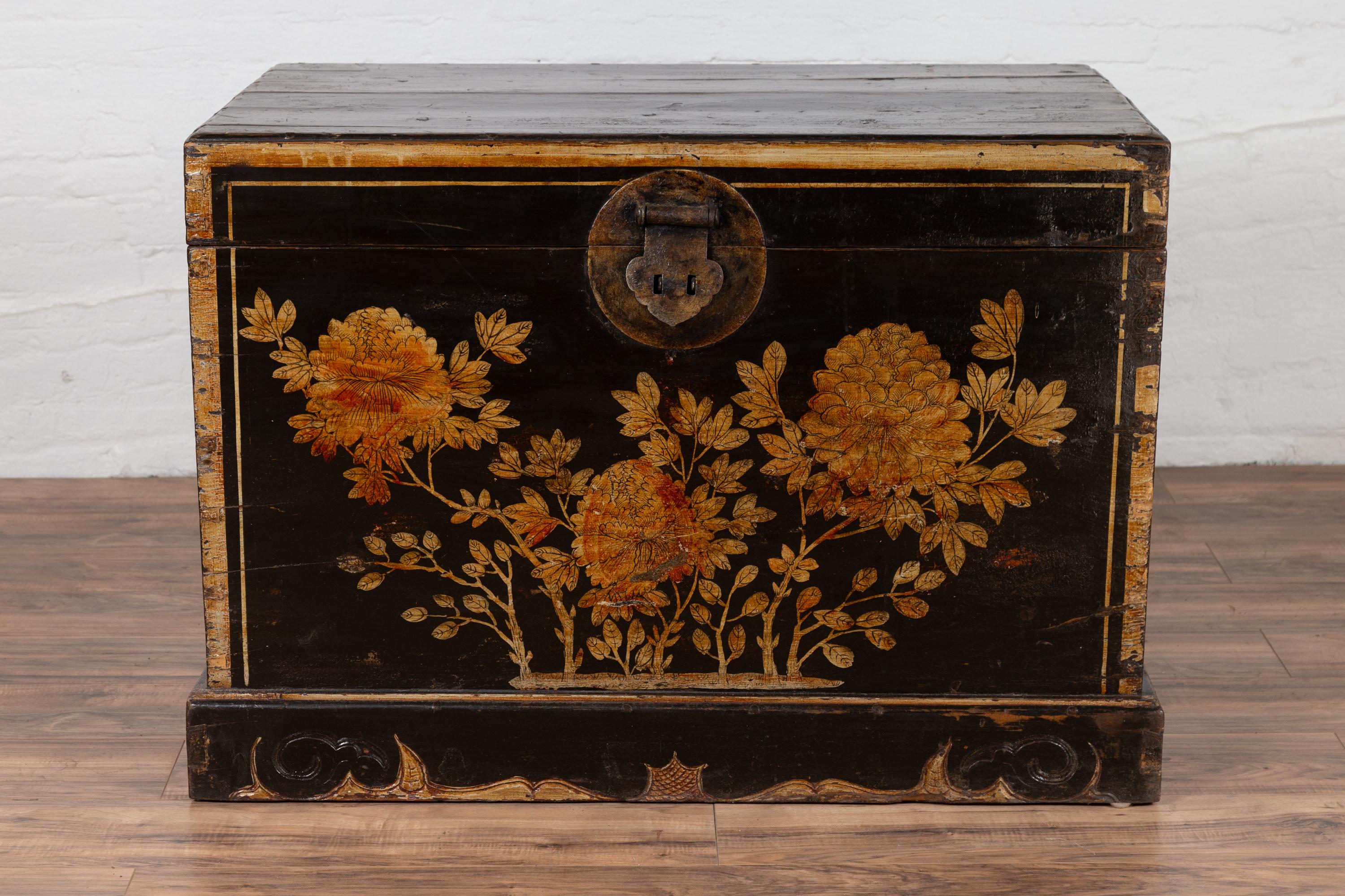 An antique Chinese black lacquered trunk from the early 20th century, with golden floral décor. Born in China during the early years of the 20th century, this Chinese trunk will be a tremendous decorative item in any room. Presenting a black