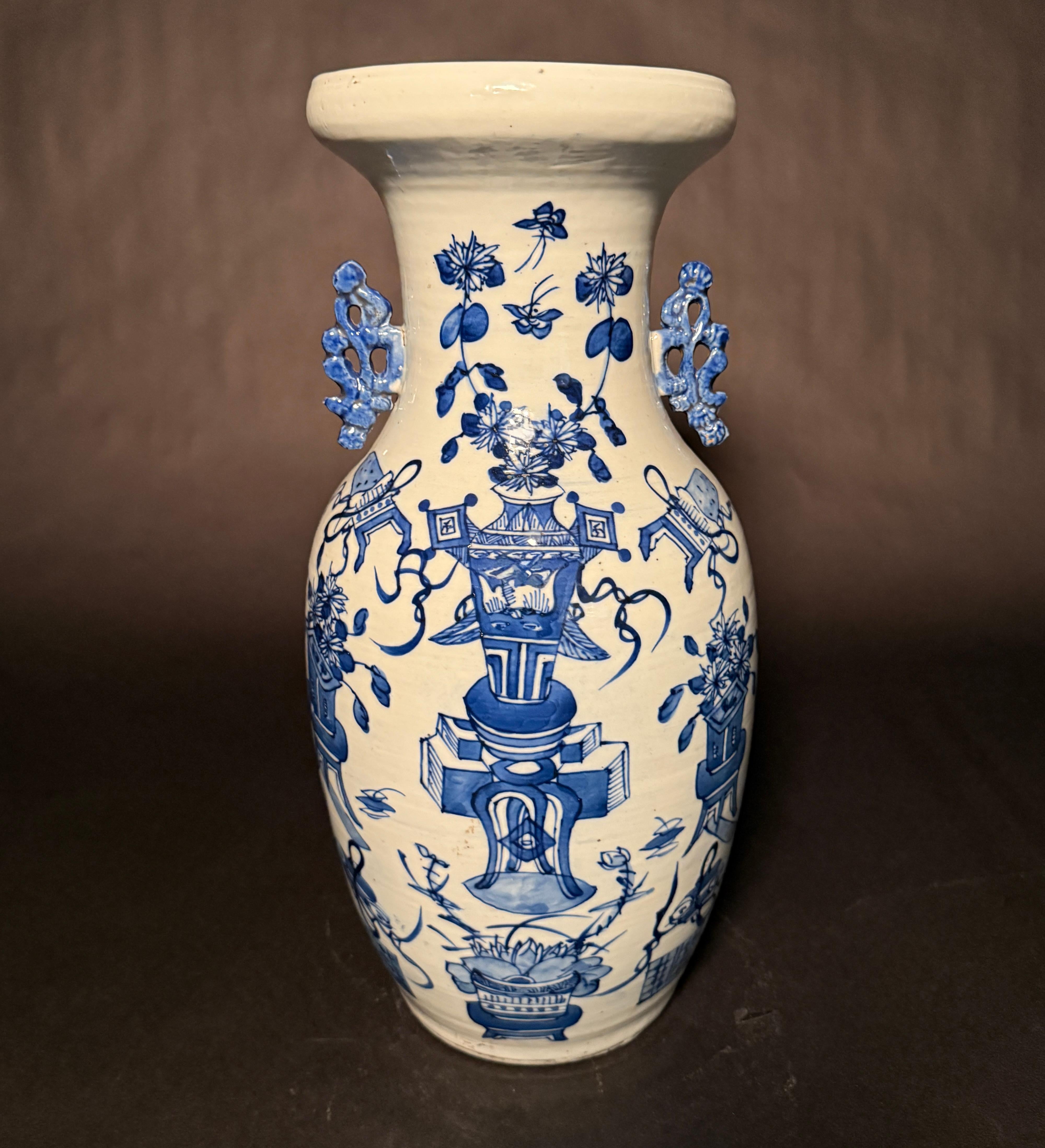 A large antique 19th century Chinese floor vase having a celadon ground and blue and white underglaze decoration to the body. The underglaze decoration is of Chinese decorations such as urns, vases and planters with foliage. Applied decorative