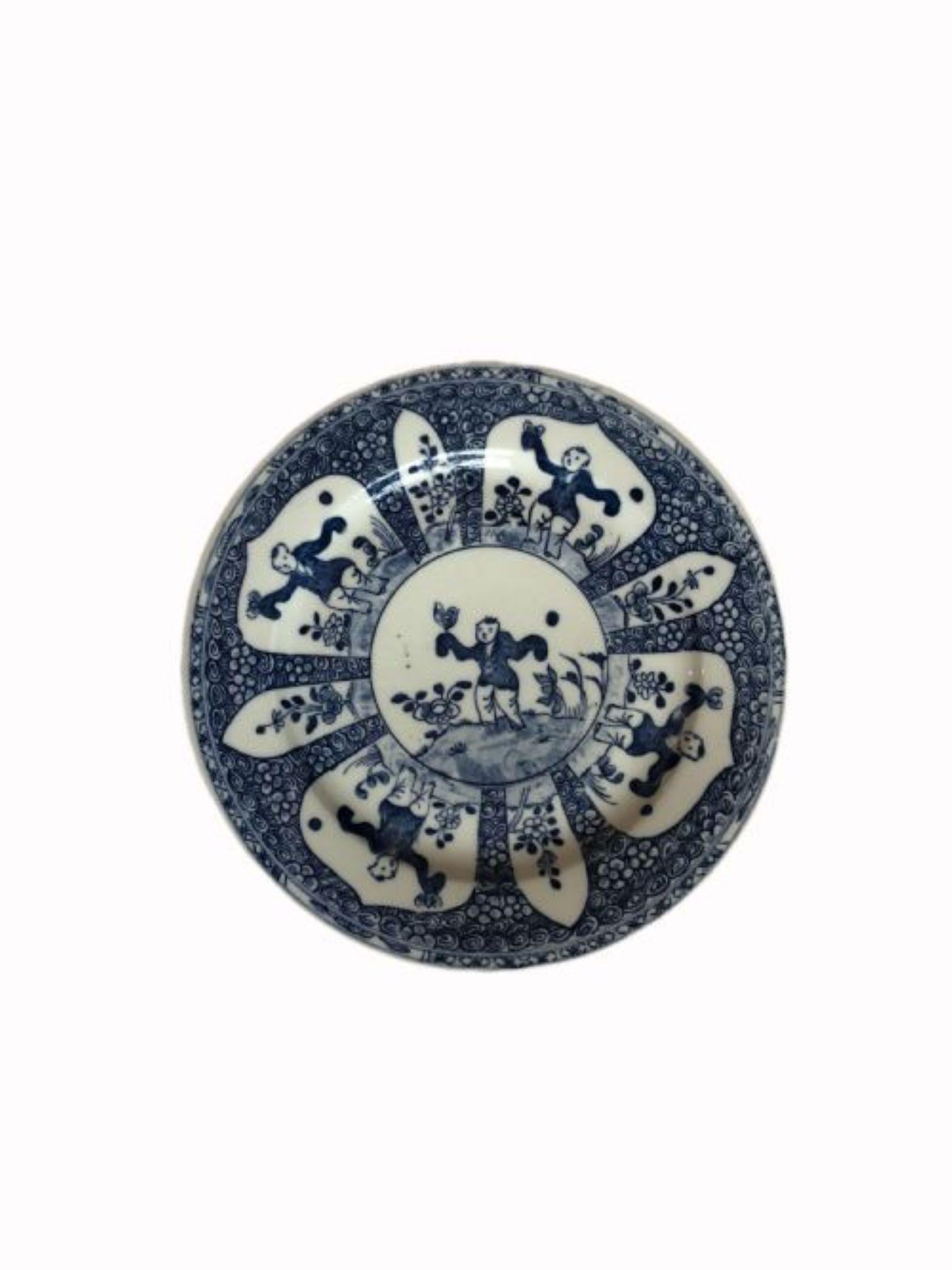 Antique Chinese Blue & White hand painted plate having lovely hand painted panels of a Chinese man holding a bird in a garden with flowers & leaves.