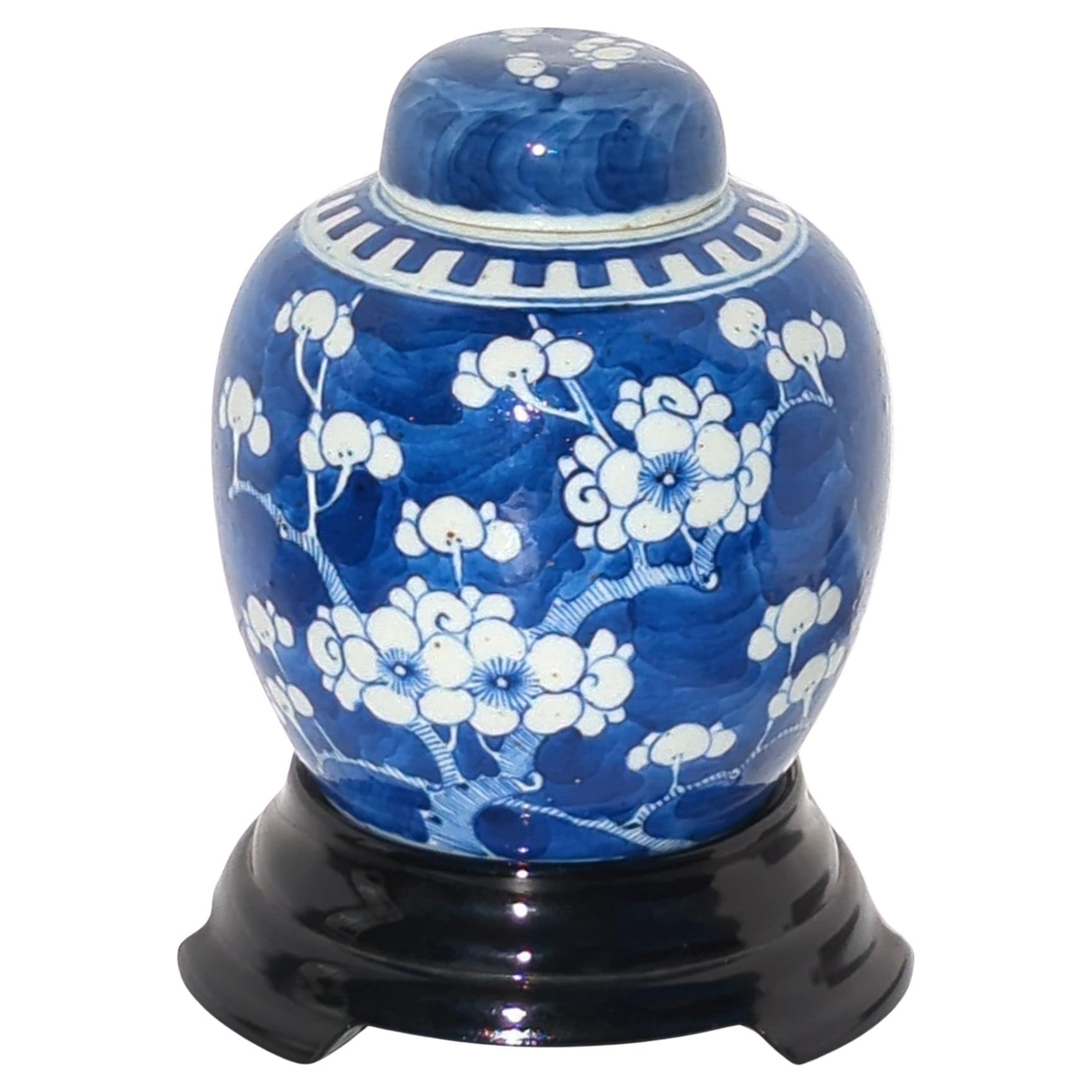 Antique early 20c Chinese export blue and white covered ginger jar, hand painted in reserve with branches of plum blossoms all over, on cobalt blue ground, with a double circle mark within the white glazed footing and a matching domed and blue and
