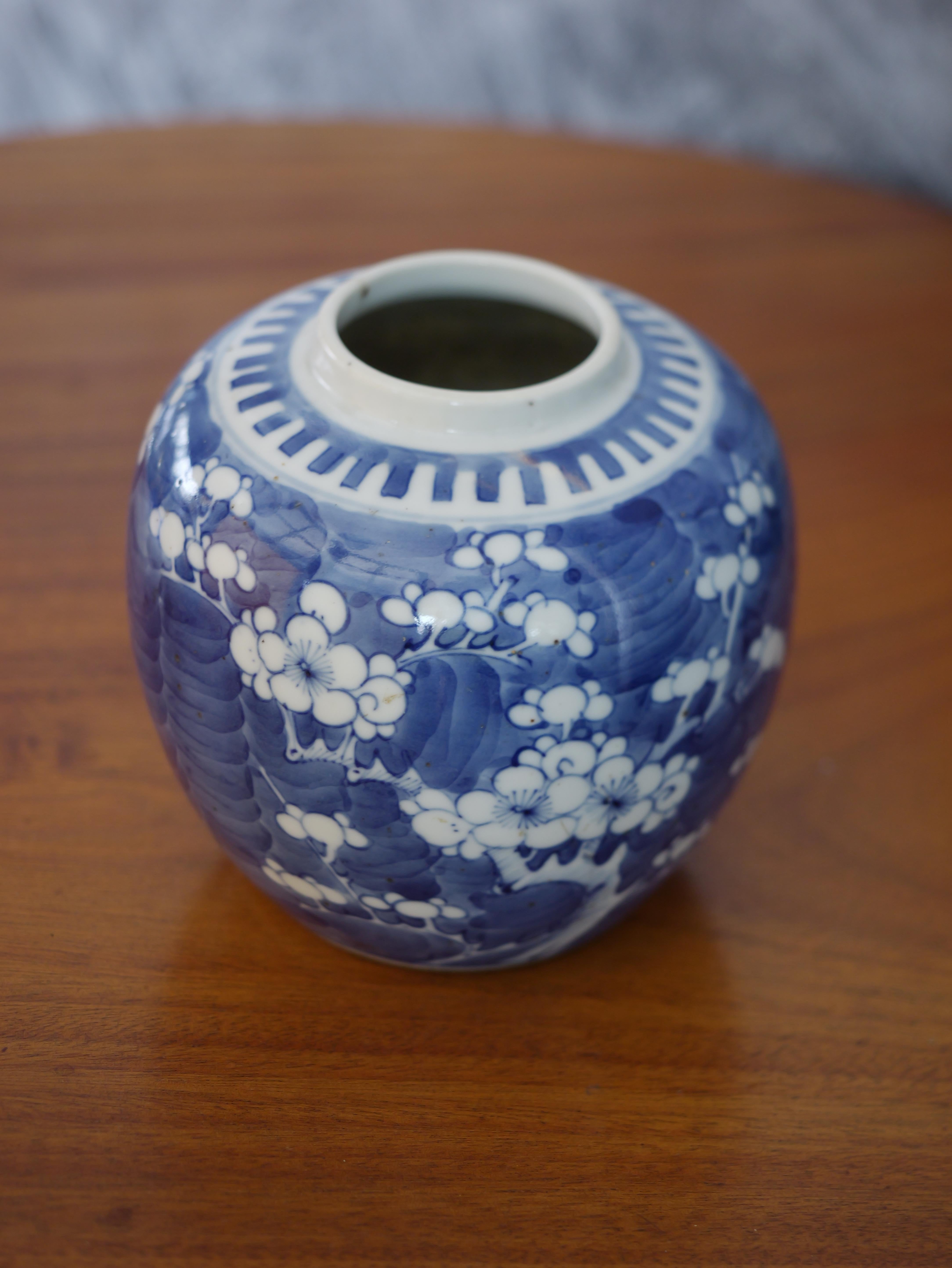 This antique Chinese Blue & White Prunus Blossoms Covered Ginger Jar from the Qing dynasty, dating from the mid-19th century, is a stunning piece despite missing its lid. The jar features classic blue and white hand-painted prunus blossom motifs, a