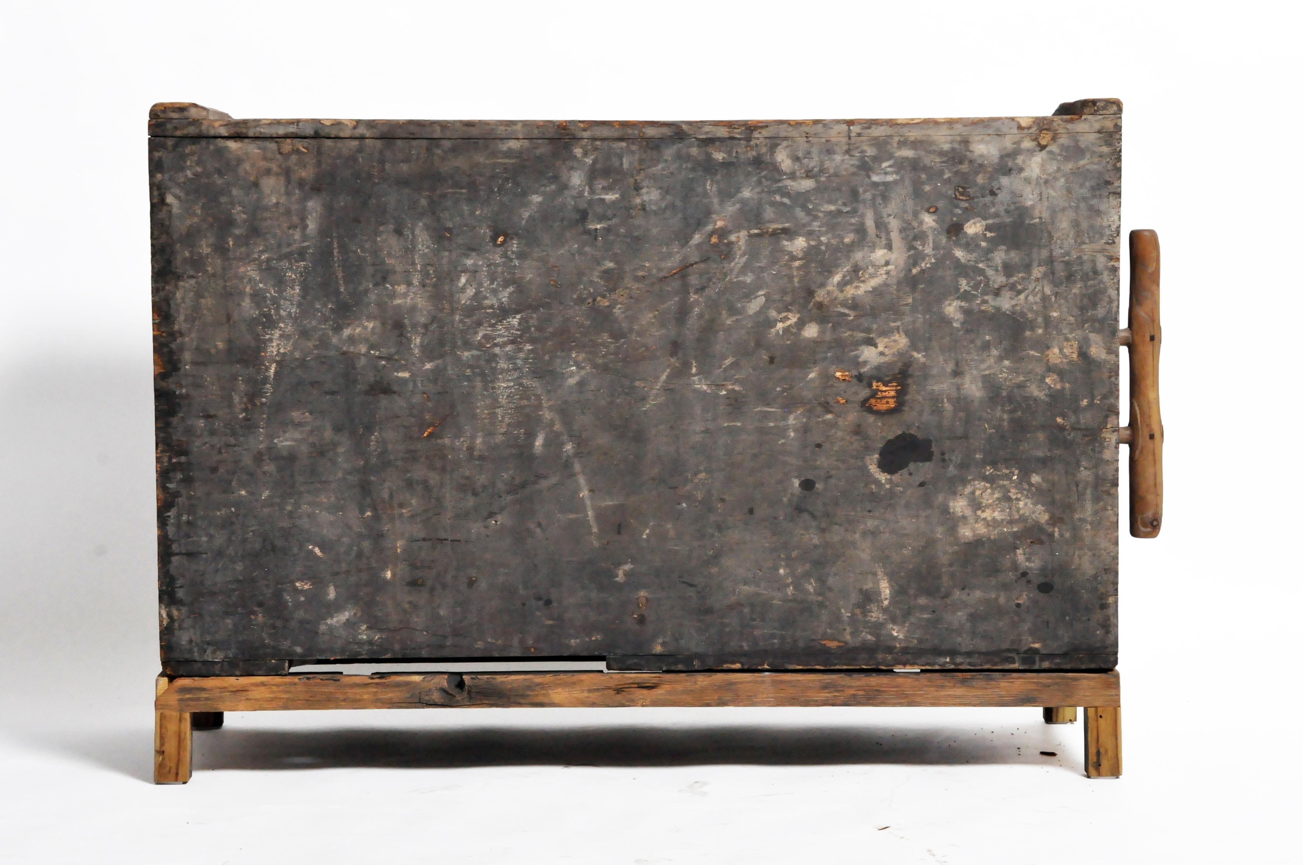 Antique box bellows from China made from wood and finished in black lacquer.  Over extended use, the piece has developed a rich gray patina.   It has been fitted with a modern stand made from reclaimed wood. 