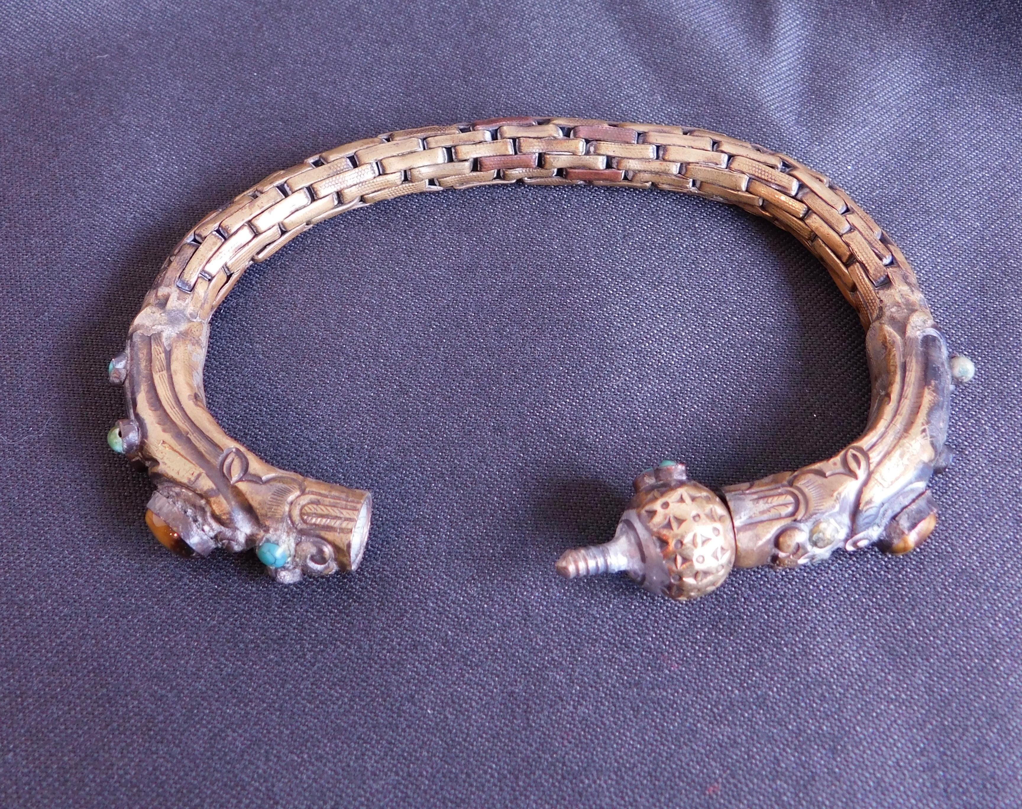 Handmade Chinese Minority bracelet of brass decorated with bezel set turquoise and tiger eye stones. The end can be unscrewed .
Interior circumference=19.50 cm