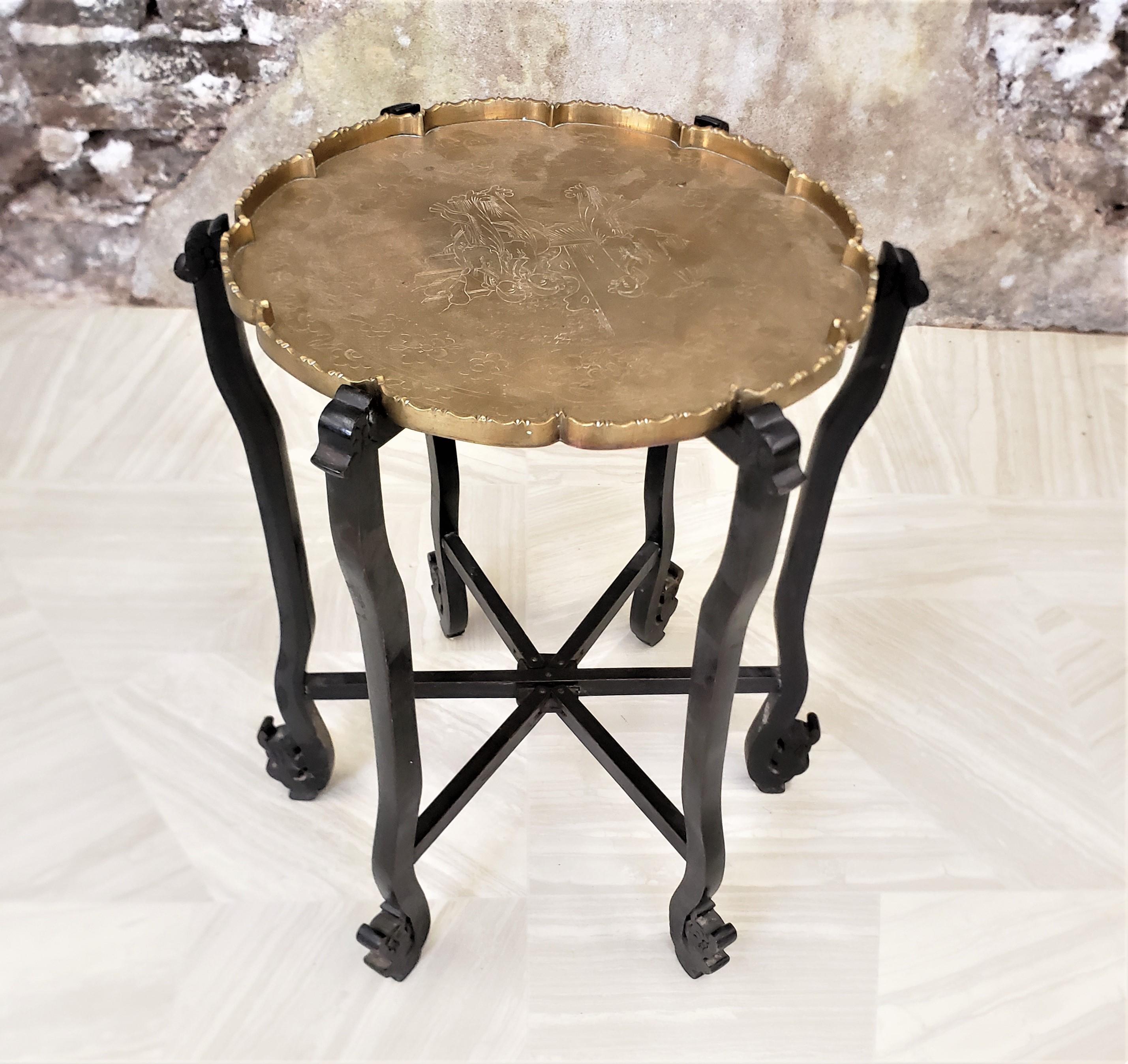 Cette petite table plateau antique en laiton ne porte pas de signature du fabricant, mais on suppose qu'elle a été fabriquée en Chine vers 1920 dans le style d'exportation chinois de l'époque. Le dessus du plateau est fait en laiton massif avec une