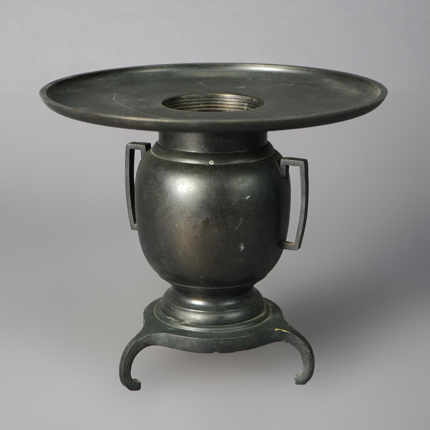 An antique Chinese censor offers bronze construction in urn form with oversized lip, double handles and feet, 19th century

Measures - 8.25