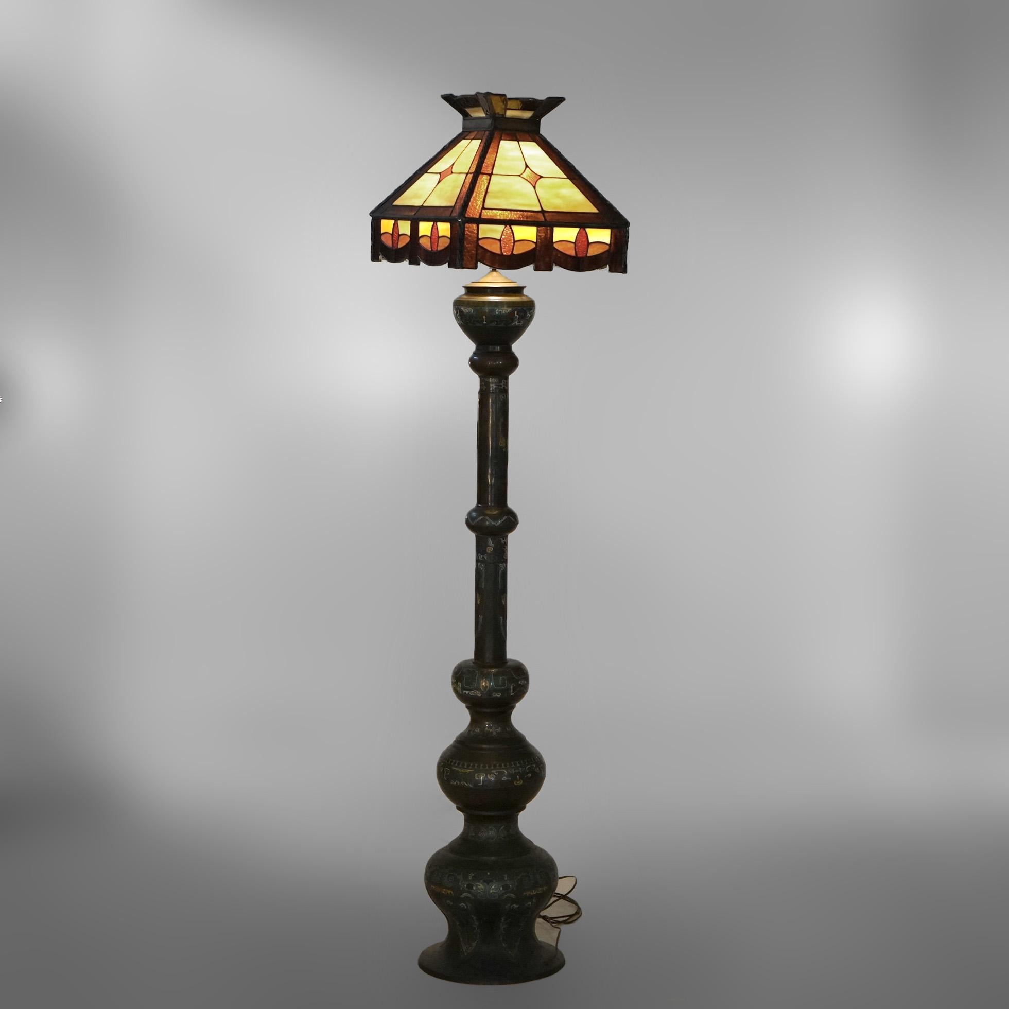 An antique floor lamp offers leaded glass shade over Chinese Champleve bronze base, electrified for US use, c1920

Measures- 75.75''H x 16.25''W x 16.25''D