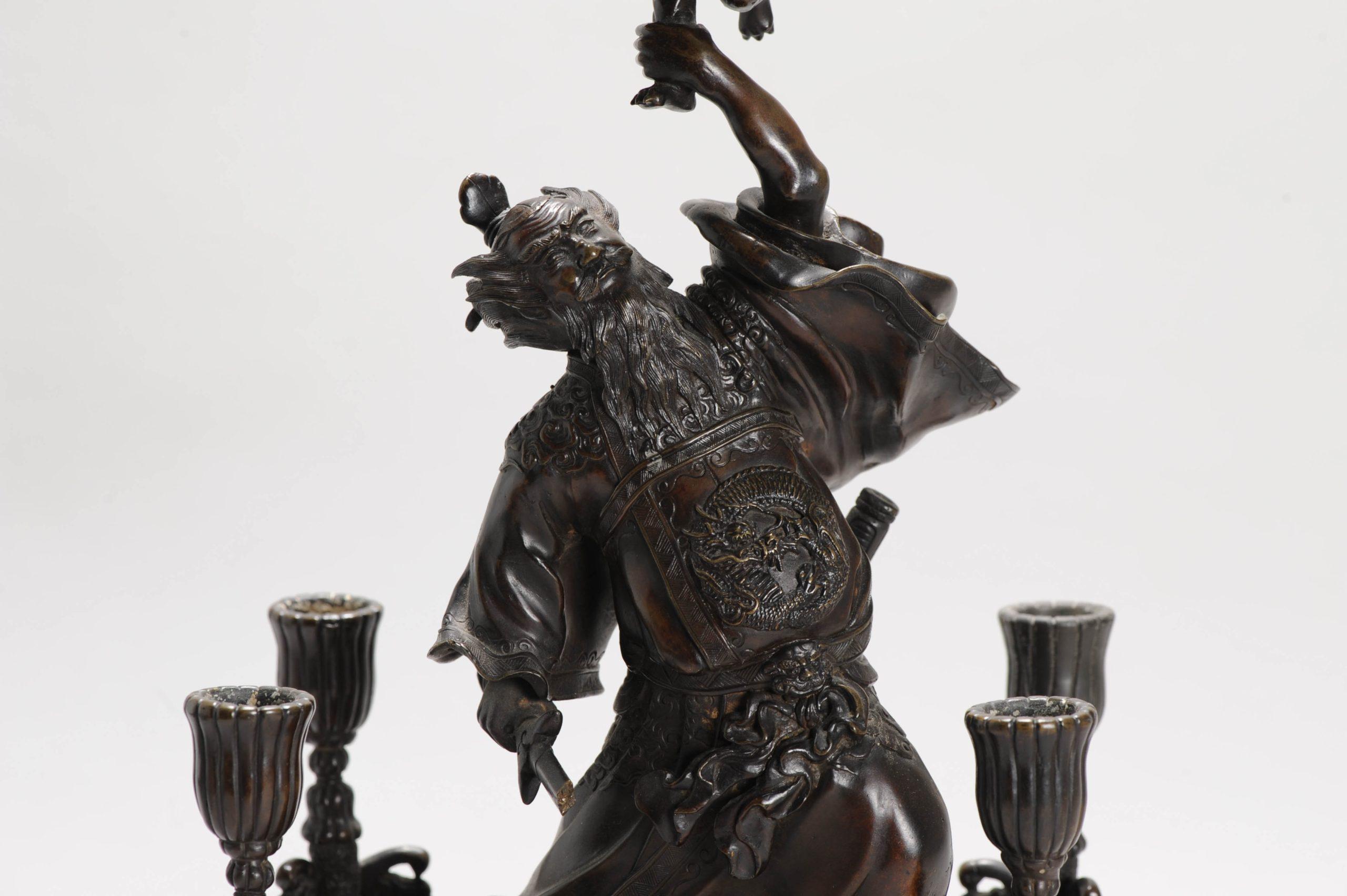 

BRONZE top level Chinese statue/candle holder. Depicting Zhongkui and Child.

Besides being a vanquisher of evil, Zhong Kui has the power to bring good fortune. He is associated with auspicious symbols of Chinese iconography, for example bats or