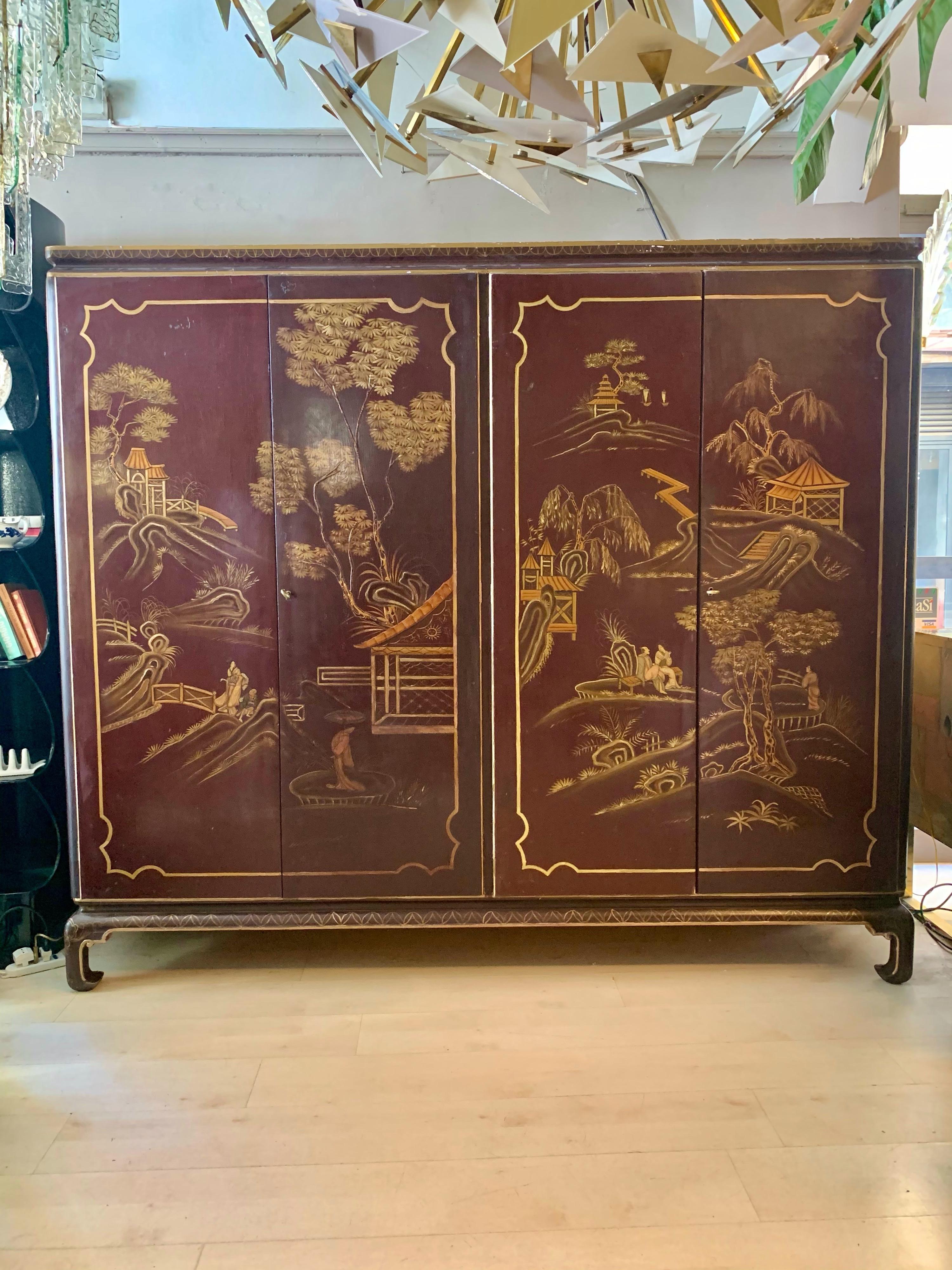 Antique English Chinoiserie storage cabinet with hand-painted Chinese décor depicting people and traditional architectures in a landscape. The doors and the sides are hand-painted Chinese scenes, presenting characters set among traditional