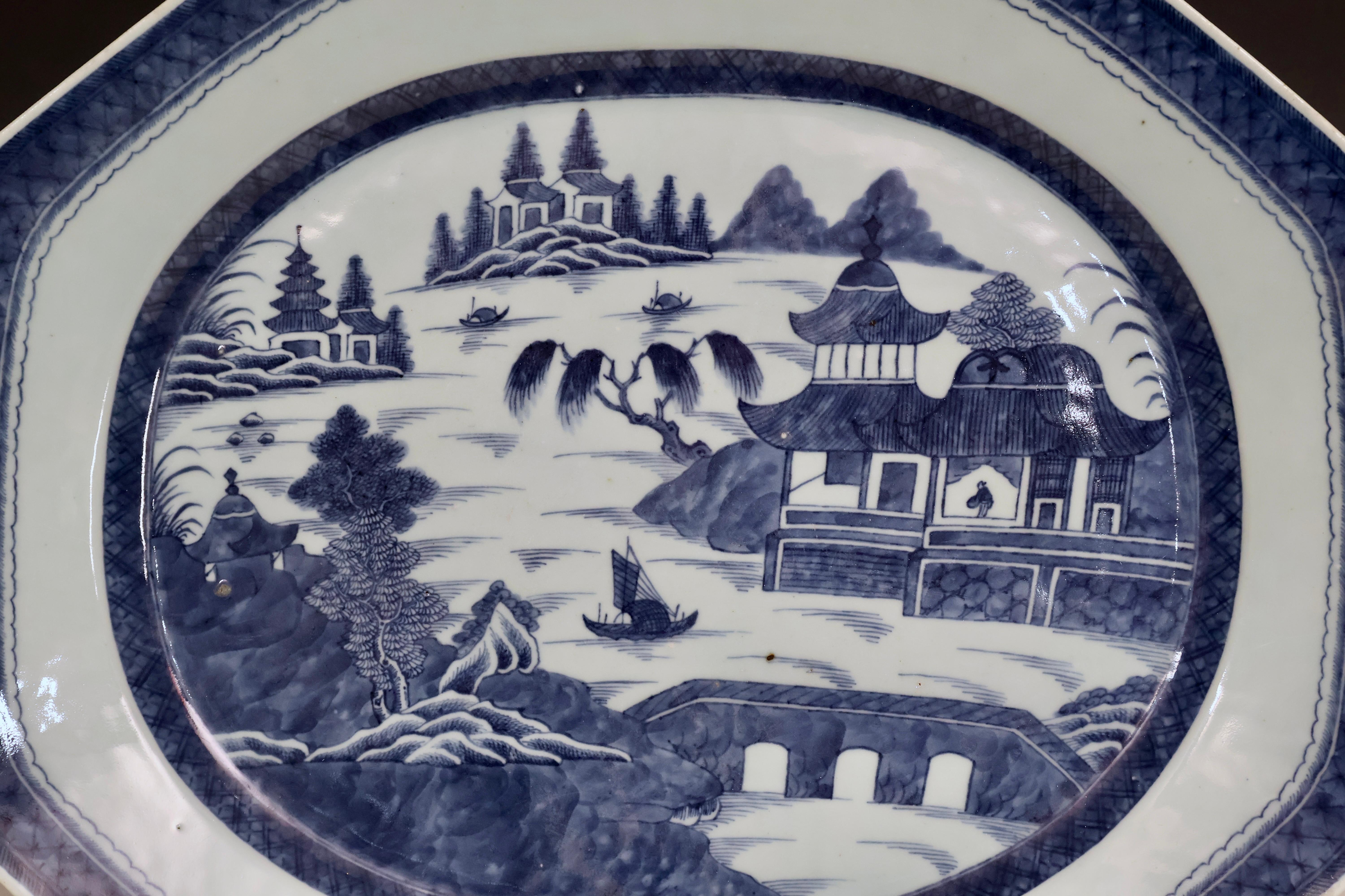 Ce grand plat de service ancien en porcelaine d'exportation chinoise bleu et blanc de Canton est un bel exemple de la vaisselle de Canton du début du 19e siècle. Représentant un paysage chinois serein composé de maisons, de bateaux et de saules dans