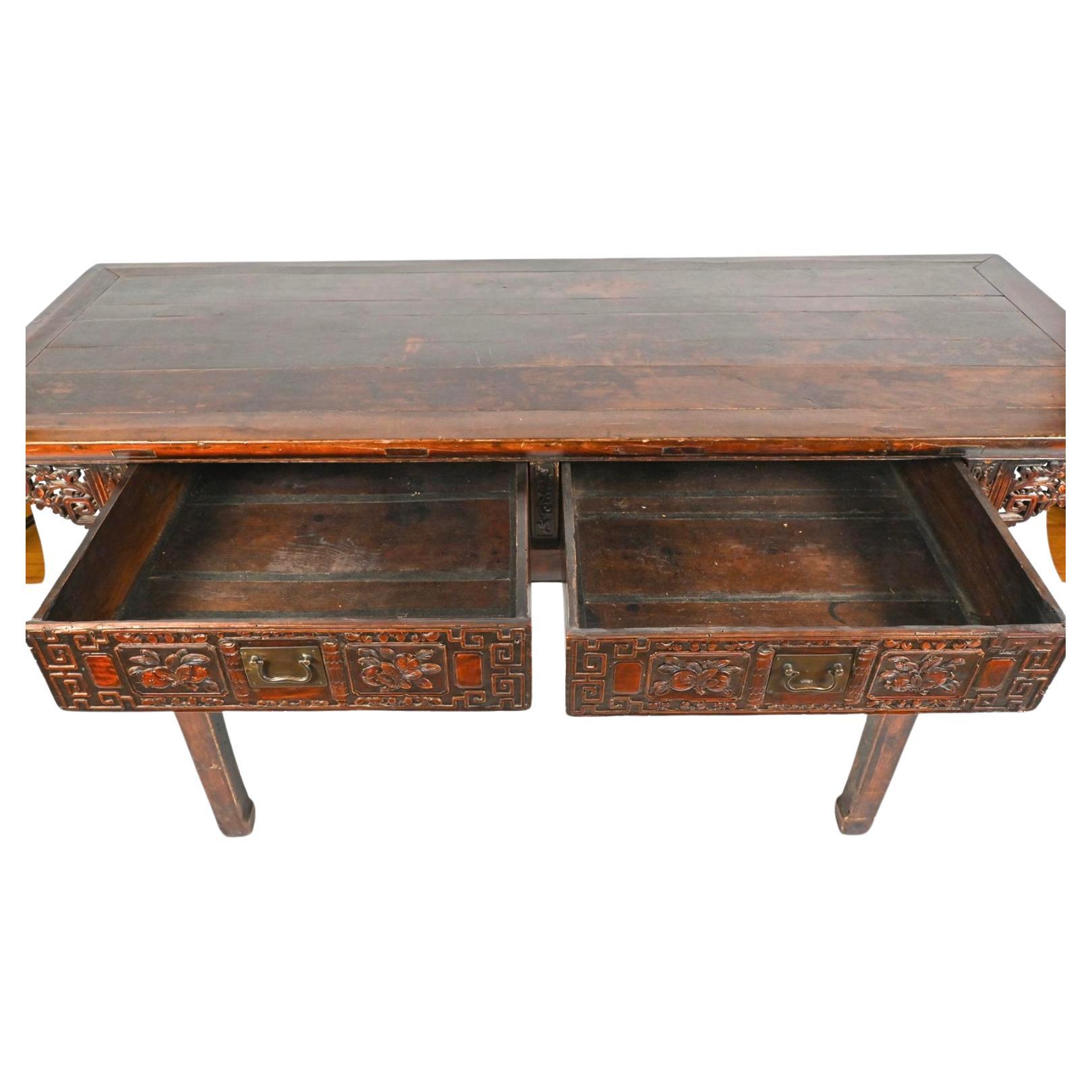 Late Qing Chinese Carved Altar Table with a paneled top and pierced carved skirt. Features two deep heavily carved dovetailed drawers with chamfered bottoms, through tenon construction. Elaborate very detailed carving throughout. Back sides and