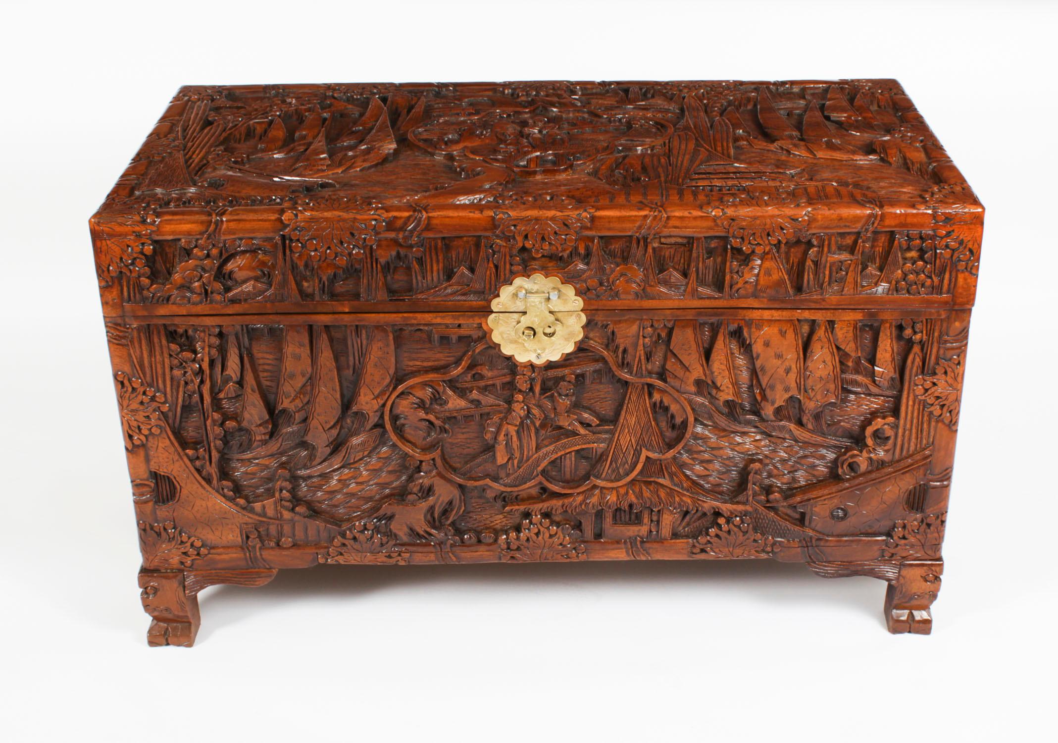 This is a stunning antique Chinese camphor wood trunk with brass fittings, and featuring an interesting desert scape scene, circa 1920 in date. 

Elaborately detailed, the trunk has been crafted from camphor wood and features exquisite  carved